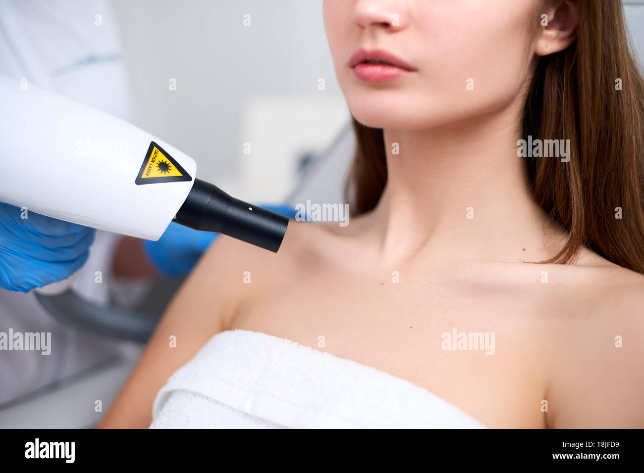 Mole removal laser sur la poitrine d'une femme dans un salon de beauté.  Pose sur patient medical fauteuil. Cosmétologie matérielles. Médecin  coiffeur retrait tache o Photo Stock - Alamy