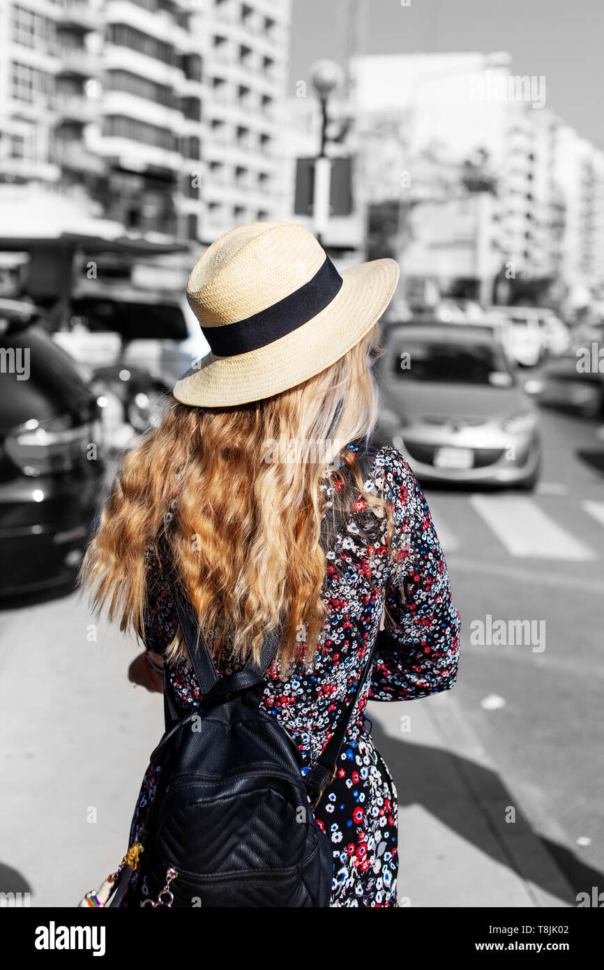 Blonde woman traveler in hat visiter ville, coloration sélective, vue arrière Banque D'Images