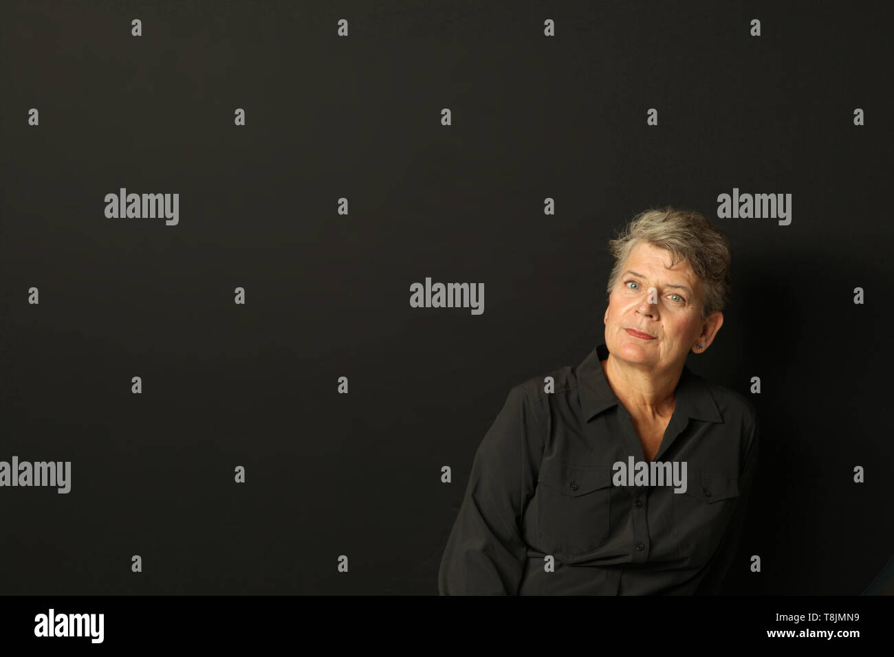 Attrayant, pensive woman against black background, studio shot, modèle sorti, USA, le 2 mai 2019, © Katharine Andriotis Banque D'Images