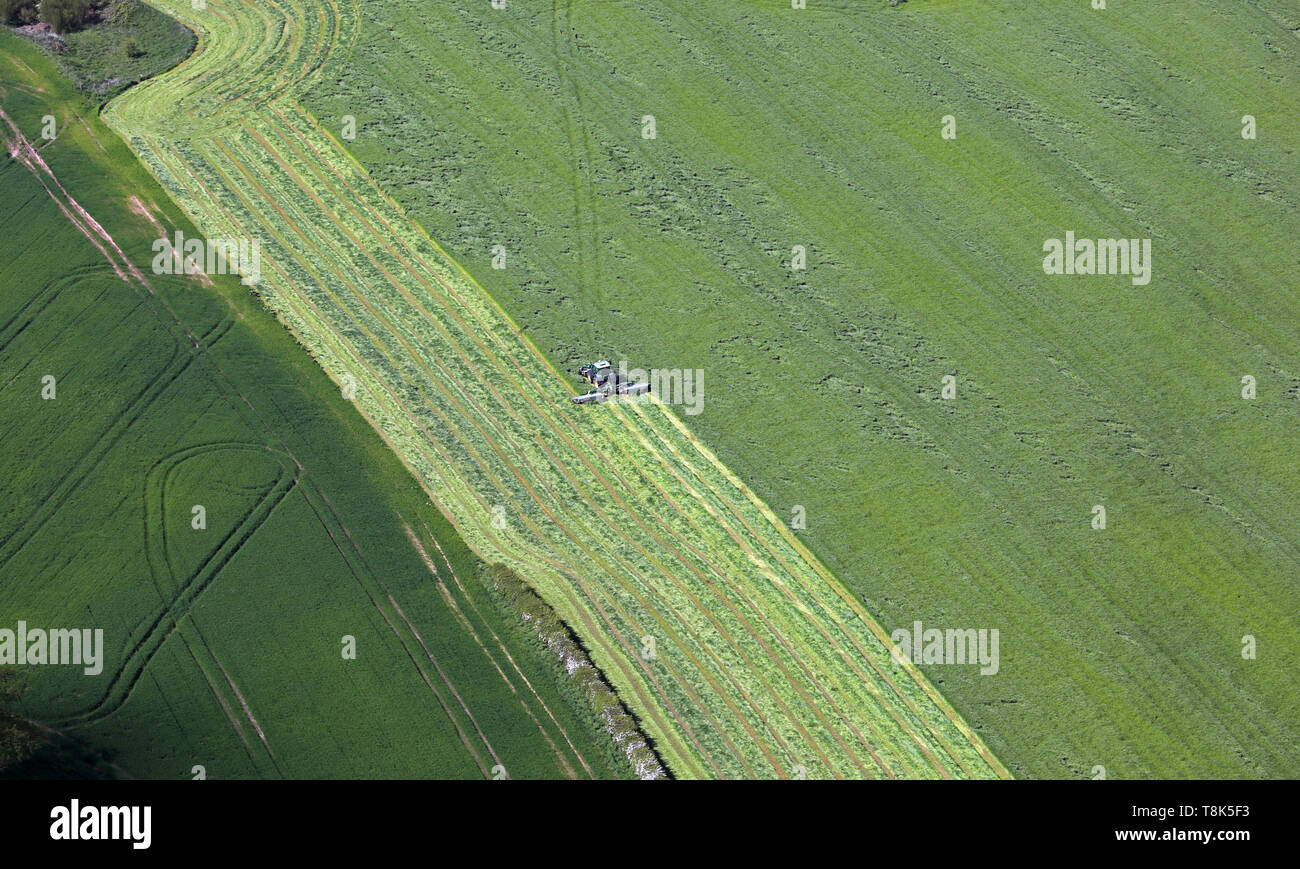 Vue aérienne d'un agriculteur coupé de l'herbe pour le foin ou ensilage dans Cheshire, Royaume-Uni Banque D'Images