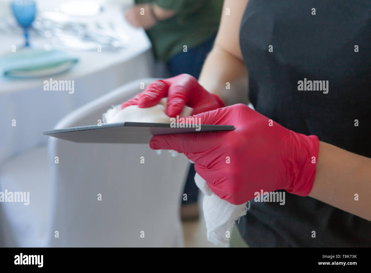 La fille en rouge gants nettoie la plaque, la préparation de la célébration du mariage Banque D'Images