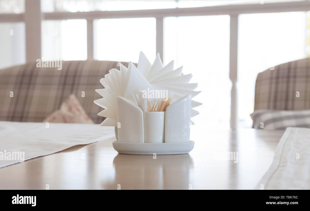 Serviettes blanches dans les supports sur table en bois, close-up Banque D'Images