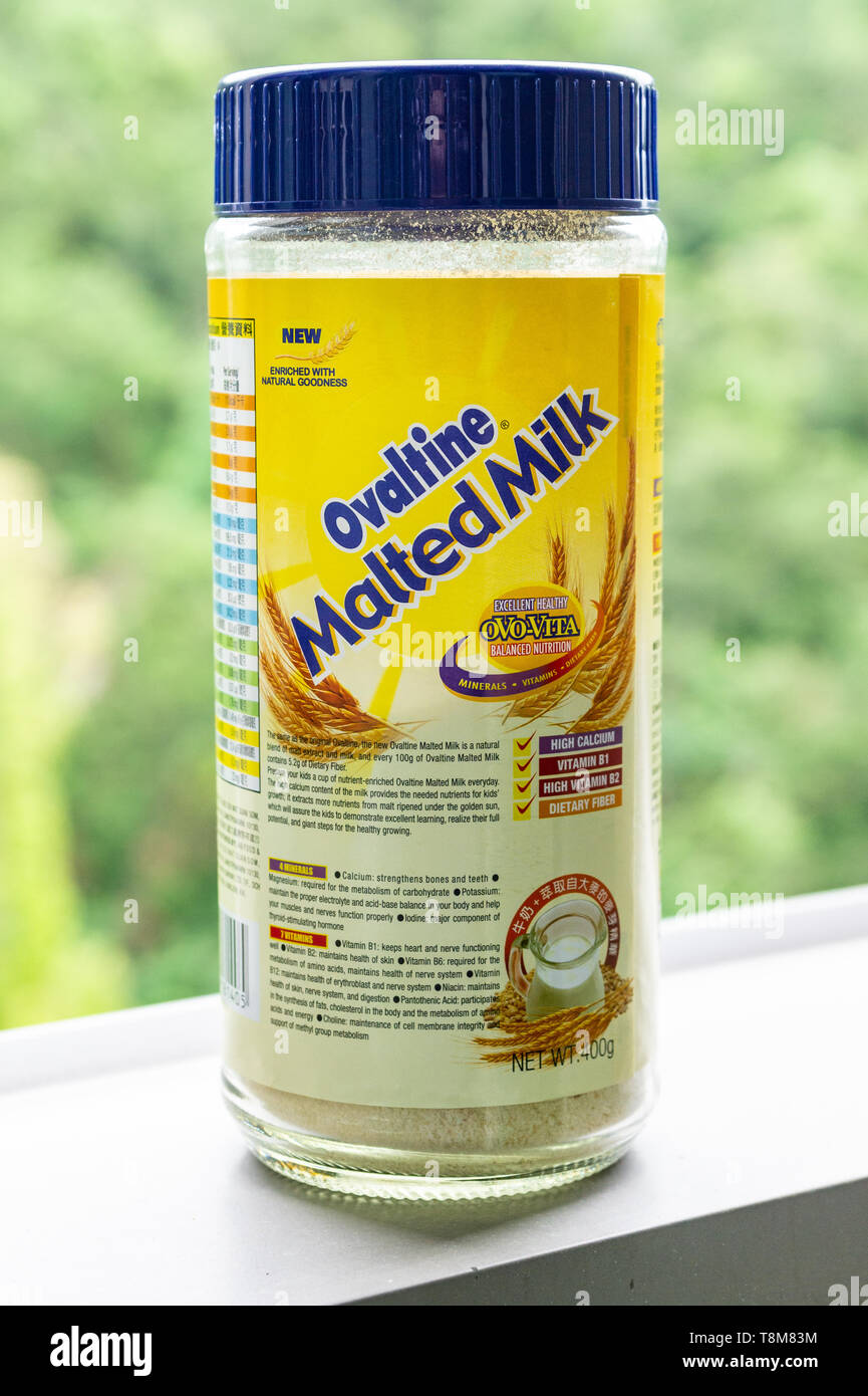 Photo de l'Ovaltine jar, le français et l'étiquette en chinois, en partie contre l'arrière-plan naturel Banque D'Images