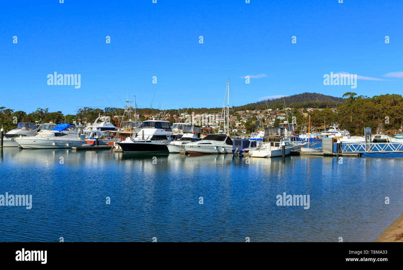 St Helens marina et bateaux de pêche sur la baie d'Incendies côte est de la Tasmanie en Australie avec la ville en arrière-plan avec l'exemplaire de l'espace. Banque D'Images