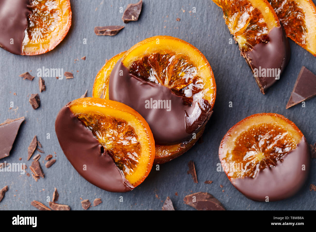 Les tranches d'orange confites dans le chocolat. Fond d'ardoise. Close up. Vue d'en haut. Banque D'Images