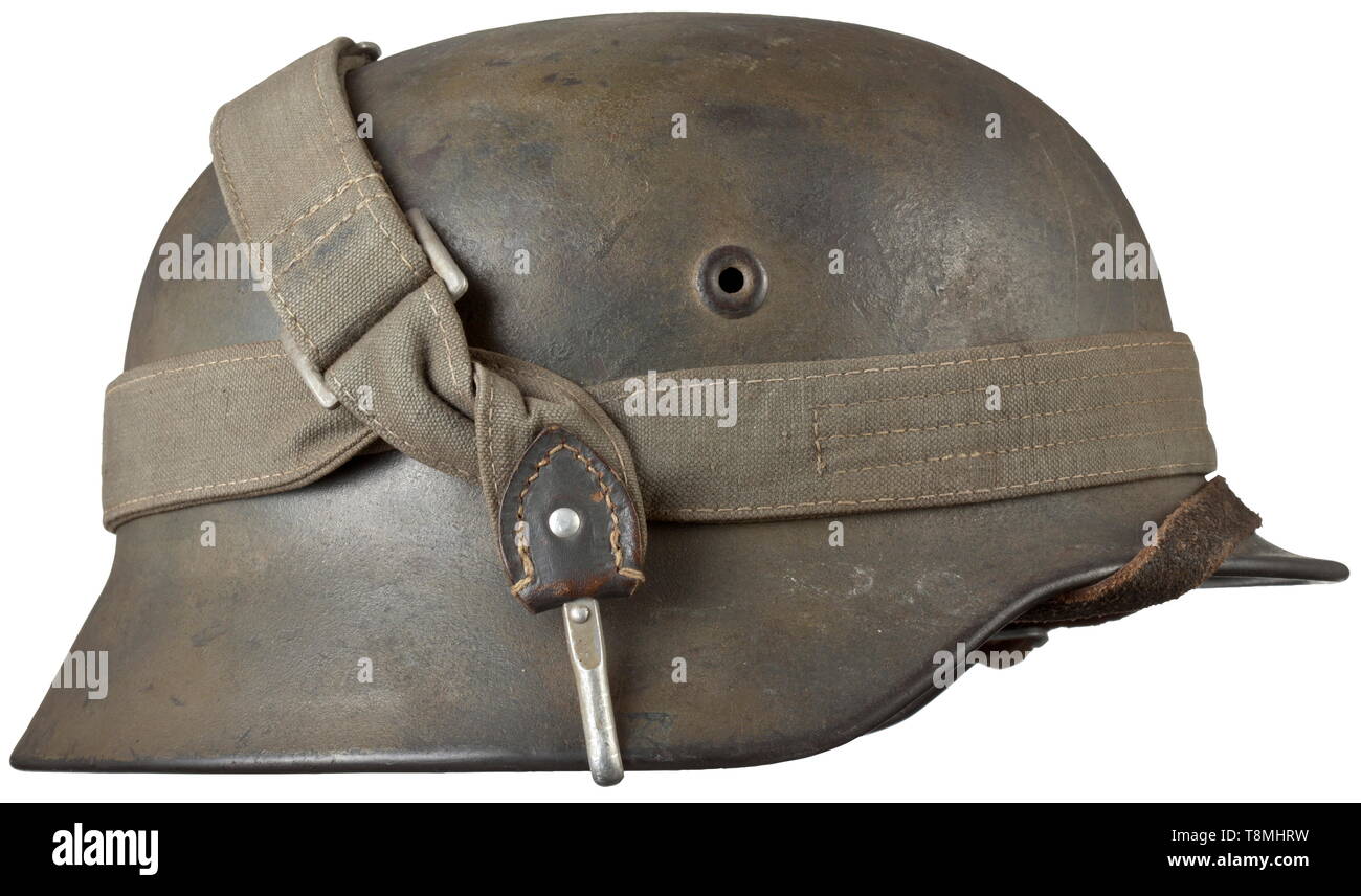 Un casque d'acier M 40 avec le camouflage du crâne d'acier avec camouflage apparent faiblement, provisoirement fixée à une lanière de sac à pain pour plus de matériel de camouflage. L'intérieur avec bouilloire d'estampillage "Q66". Complet avec revêtement intérieur intérieur et jugulaire., historique, historique, les armées de l'armée, les forces armées, militaire, militaria, 20e siècle, Editorial-Use-seulement Banque D'Images