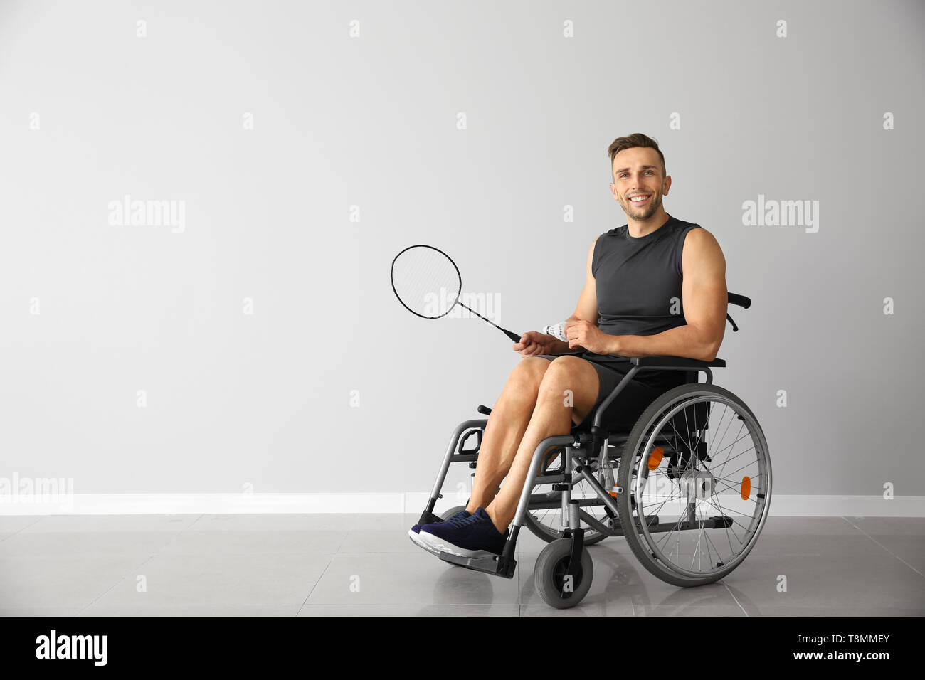 Badminton joueur assis en fauteuil roulant contre mur lumière Photo Stock -  Alamy