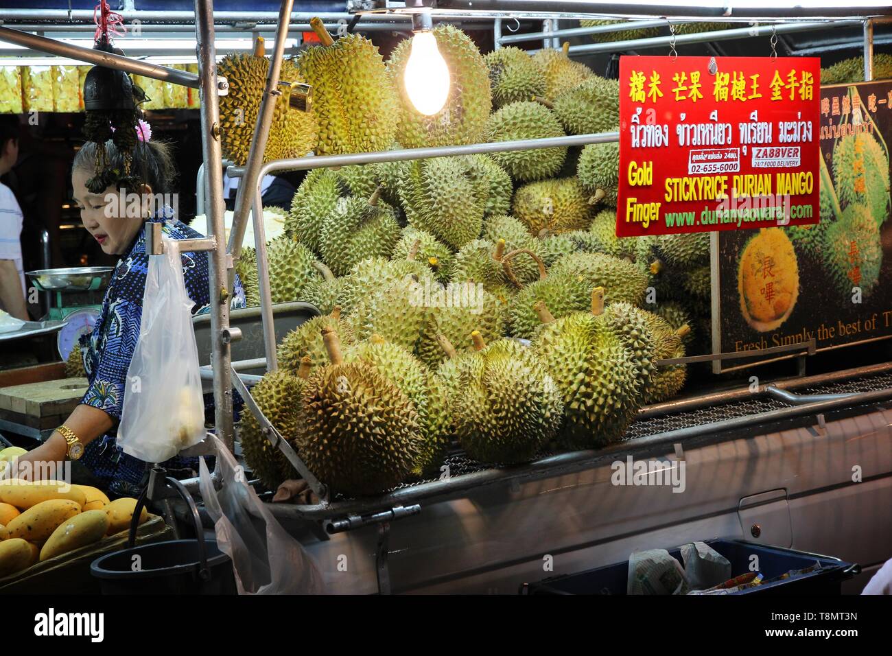 BANGKOK, THAÏLANDE - 6 décembre 2013 : homme vend durian et mangues à Bangkok. Durian est le célèbre fruit asiatique célèbre pour son odeur. Banque D'Images