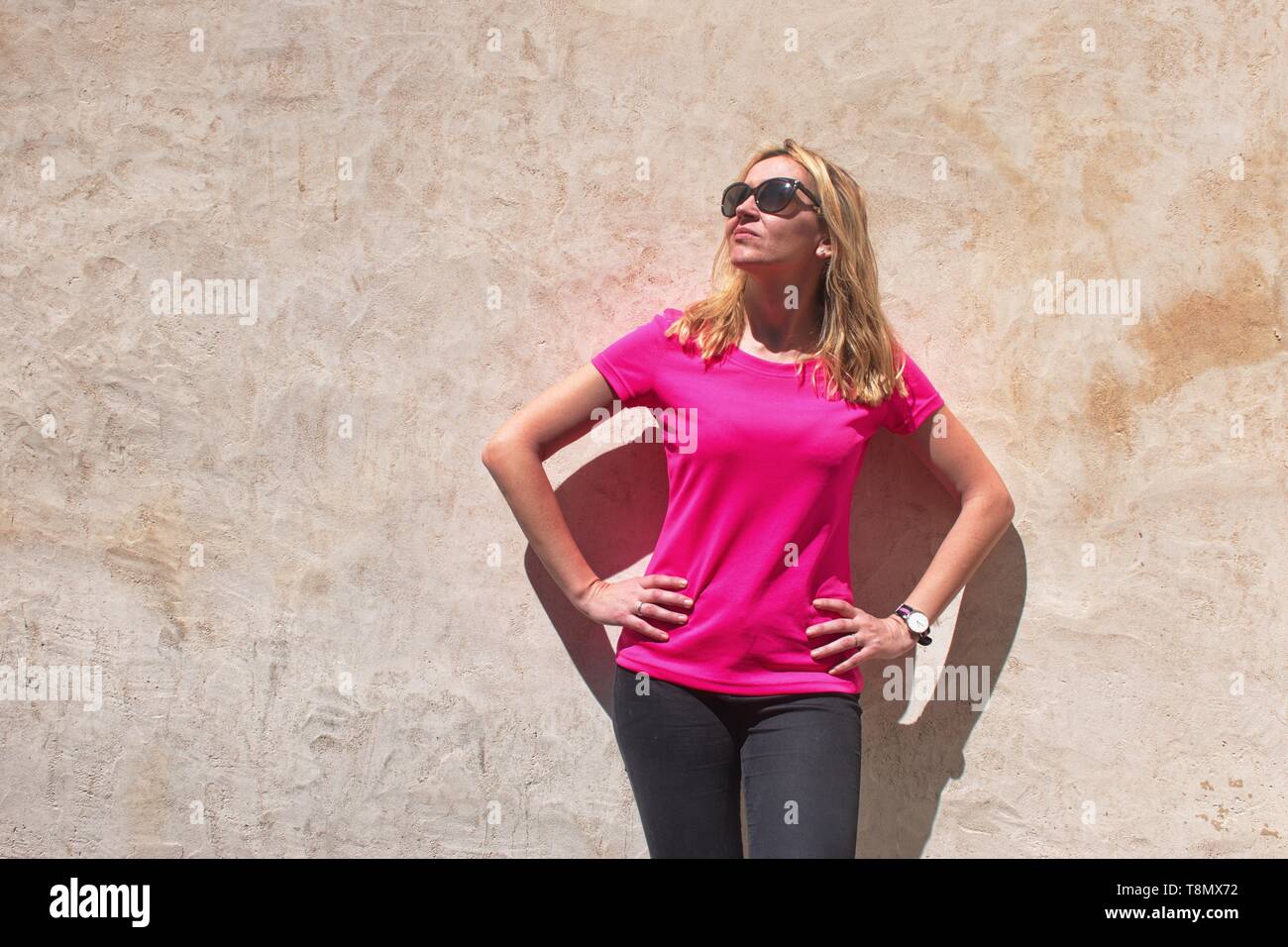 Jeune femme debout devant le mur Banque D'Images