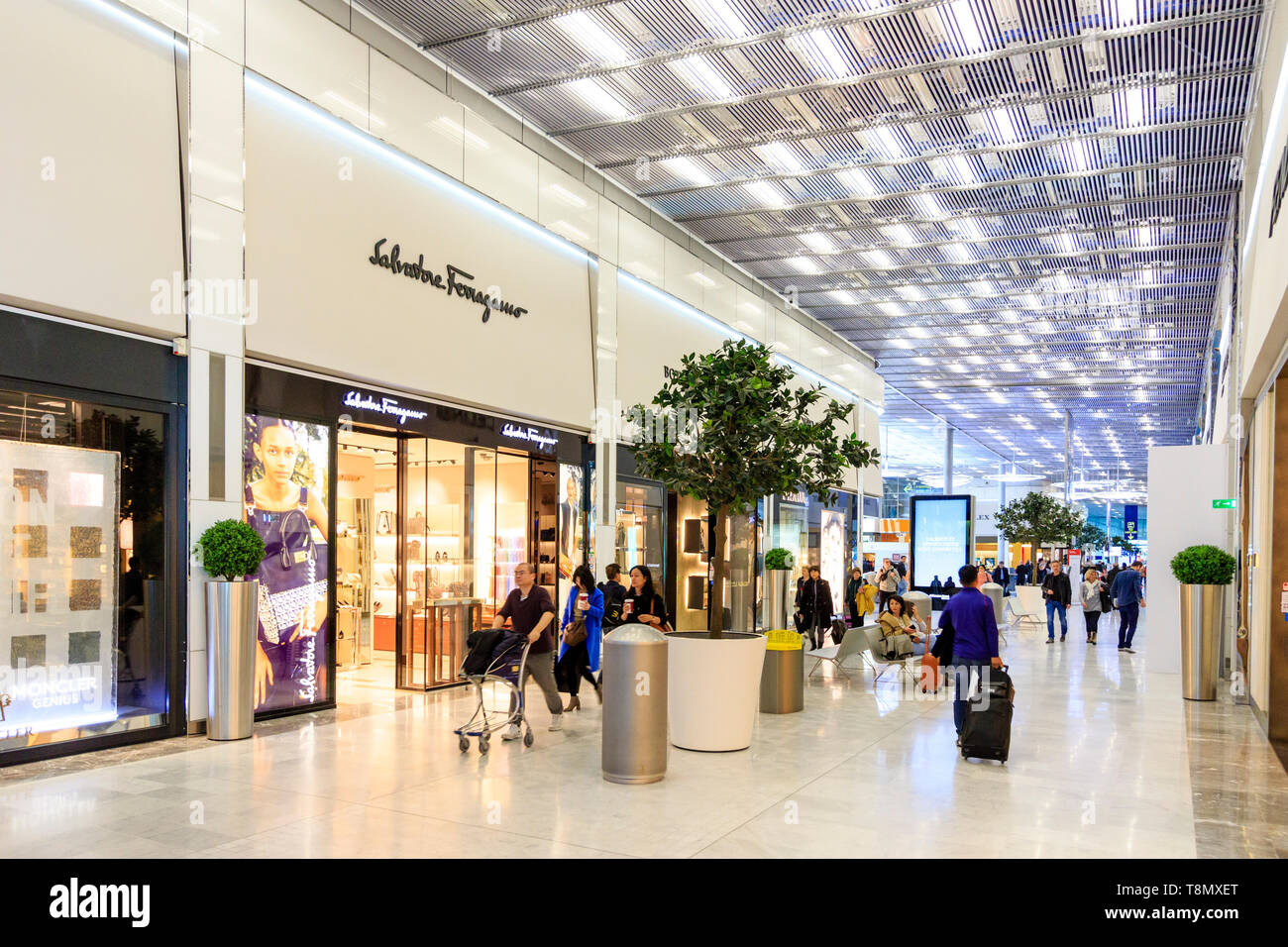 L'aéroport Charles De Gaulle, France. Vue de l'intérieur de l'édifice Terminal 2E. La salle d'embarquement internationale. Rangée de magasins de mode, Savatore Ferragamo Banque D'Images