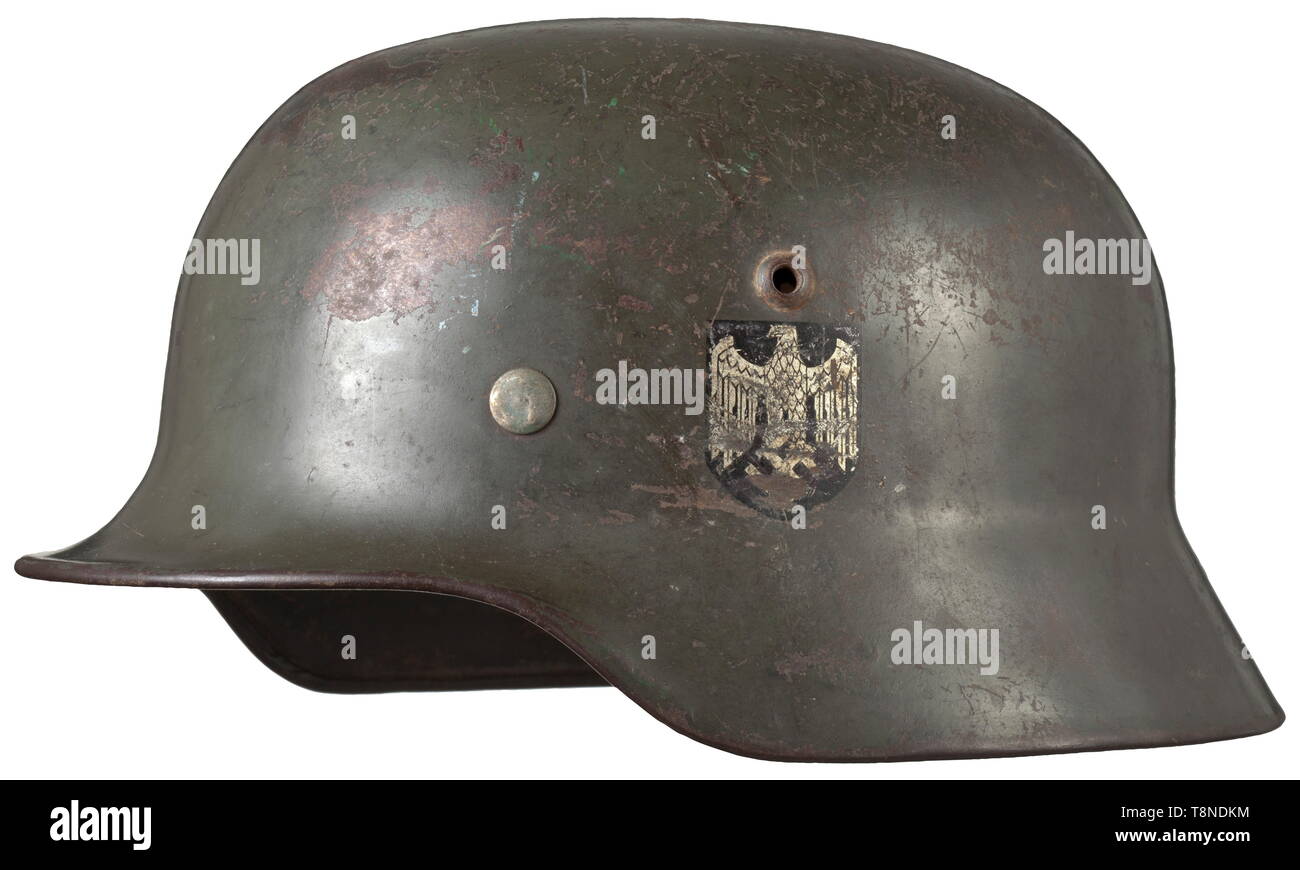 Un casque M 35 avec les décalques le crâne avec la peinture verte d'origine typique, 80 % conservés. Les autocollants sont environ 70 % intact. Doublure intérieure en cuir marron clair M 31, sans mentonnière. Le crâne est marqué '12884' et 'EF 68 ?'. Avec des signes de l'âge et l'utilisation. Historique historique rare.,, de l'armée, des armées, des forces armées, militaire, militaria, 20e siècle, Editorial-Use-seulement Banque D'Images