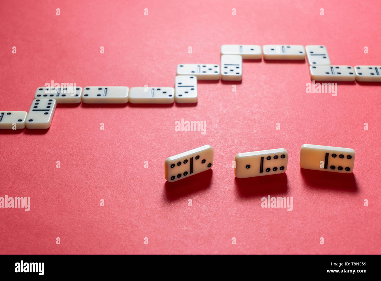Le jeu de dominos de pièces sur une surface de couleur rouge Banque D'Images