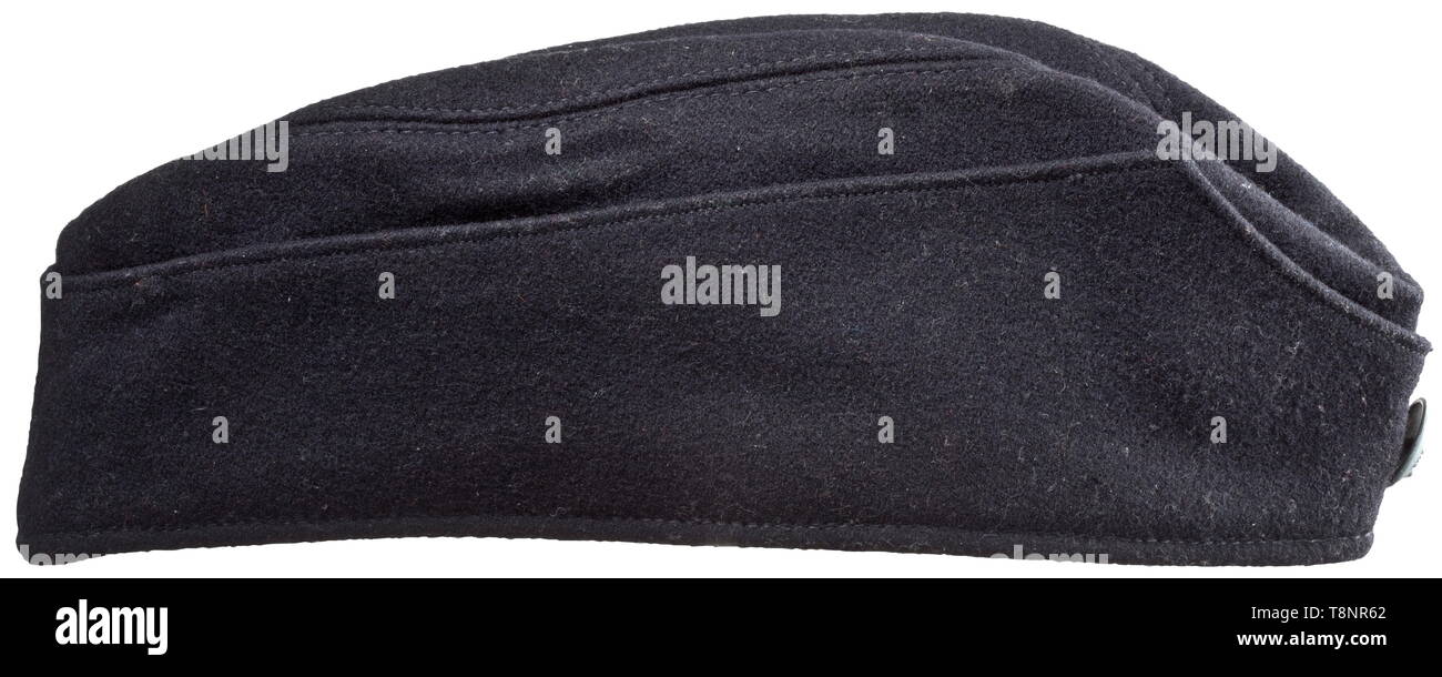 Un champ cap (garrison cap) pour l'uniforme noir des hommes enrôlés et Unterführer laine noire, l'aigle blanc sur un triangle de laine noire brodée de coton et cousue sur le côté gauche, le zinc bouton avec la tête de mort en relief fixés à l'avant par un fil de la goupille fendue, le timbre "M5/8 RZM' (Assmann und Söhne, Lüdenscheid). Doublure en coton noir avec marquage blanc '59' (taille) ainsi que '1938', va aussi avec un tag "Feldmütze für RZM SS' et 'Nr. 38516'. De légers signes de l'âge. Lieux historiques, Historiques, 20e siècle, années 1930, années 1940, Waffen-SS, division de l'armée SS, ar, Editorial-Use-seulement Banque D'Images