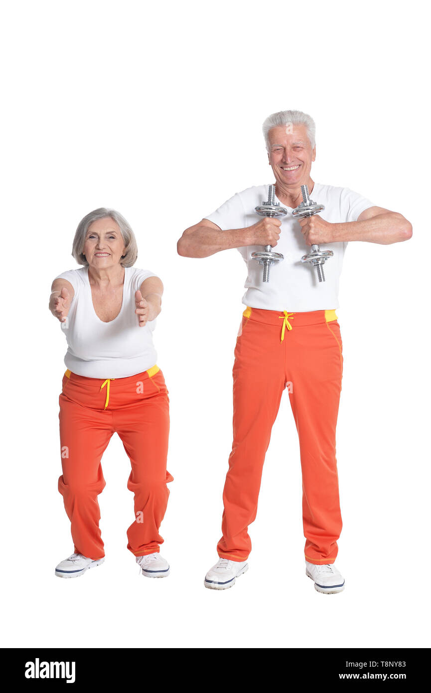 Senior couple exercising with dumbbells against white background Banque D'Images
