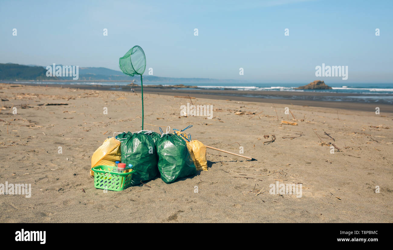 Sacs à déchets et les ustensiles sur la plage Photo Stock - Alamy