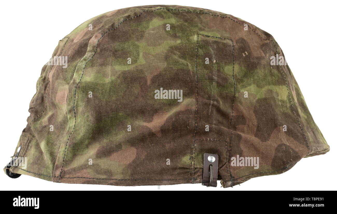 Un couvre-casque en fumée camouflage, soi-disant "Bord floue' 1er modèle sans obtenir des boucles pour matériel de camouflage, modifiable à partir de la face externe vert camouflage au printemps à l'automne à côté brun. Utilisable sur les deux faces, rivet-apposé les crochets de fixation en métal léger et poches superposées avec le fer des ressorts de tension. Estampage de taille '3' historique., historiques, 20e siècle, années 1930, années 1940, Waffen-SS, division de l'armée des SS, un service armé, forces armées, NS, le National-socialisme, le Nazisme, Troisième Reich, l'Empire allemand, l'Allemagne, militaire, militaria, ustensile, morceau de l'égalisation, Editorial-Use-seulement Banque D'Images