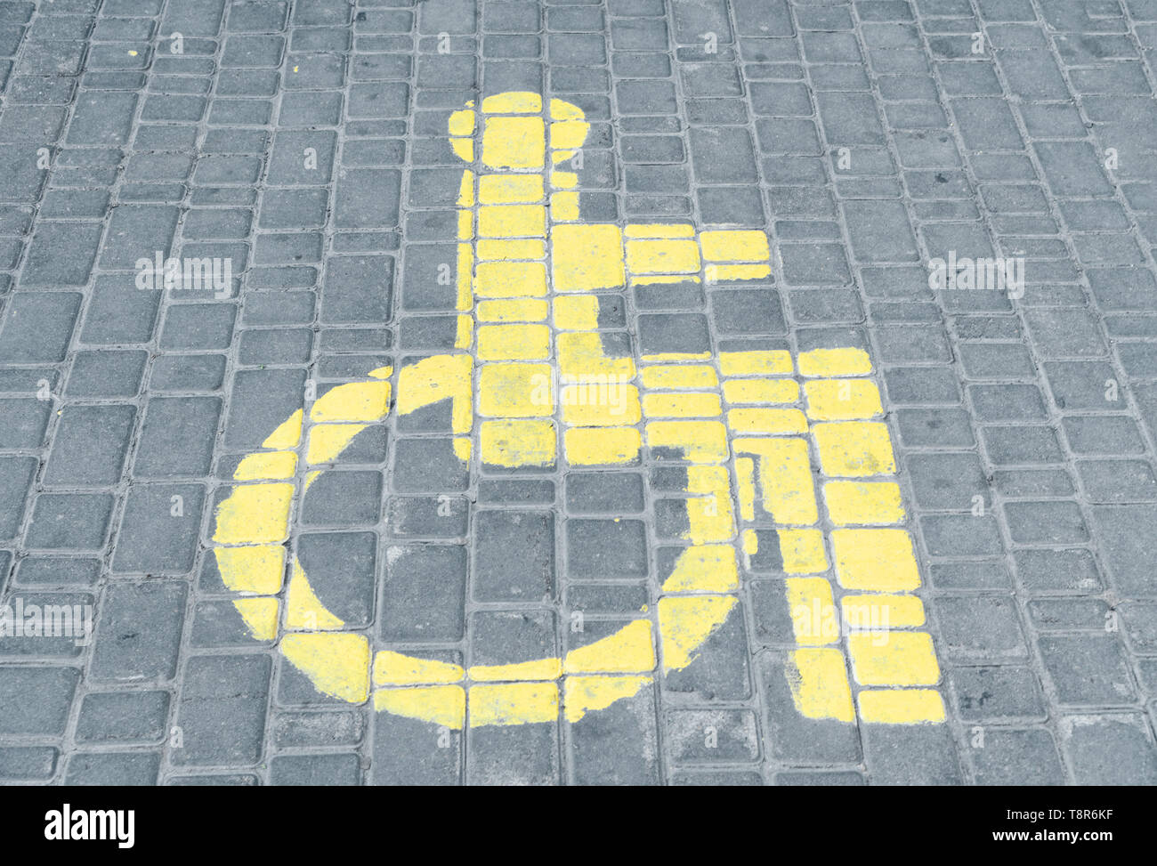 L'espace de stationnement de voitures pour personnes handicapées le signe dessiné sur la tuile. Banque D'Images