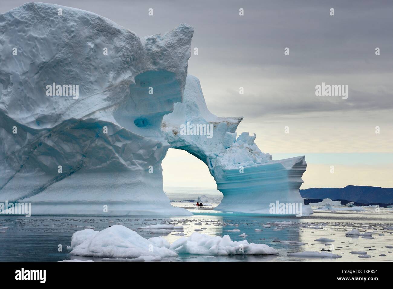 Le Groenland, côte nord-ouest, la mer de Baffin, Fjord d'Inglefield vers Qaanaaq, iceberg formant un arc et une exploration PolarCirkel bateau (Zodiac) du MS Fram navire Hurtigruten de cruse Banque D'Images