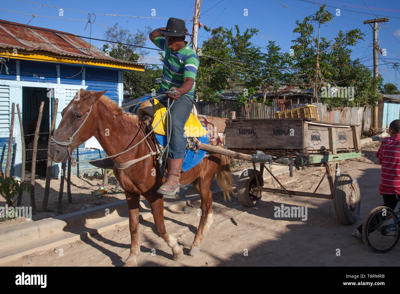 Salvaleón de Higüey, province de la Altagracia, République dominicaine - 06 mars 2011: Homme à cheval transportant des marchandises sur une route de terre dans un petit village. Banque D'Images