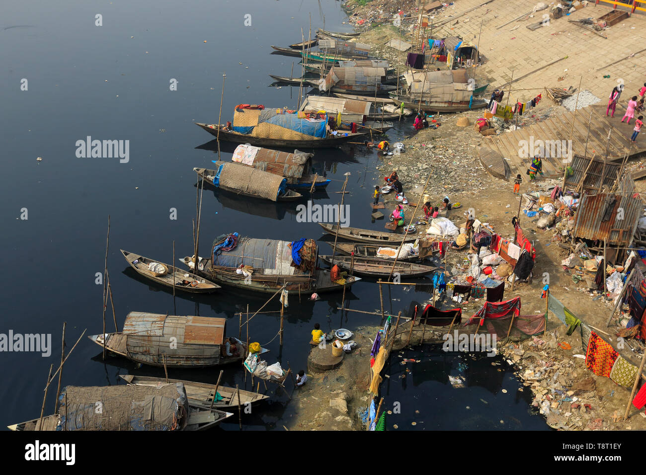 Femmes gitanes et les filles, qui vivent sur les bateaux, faire tout le nettoyage domestique dans le pitch-dark, l'eau polluée de la rivière Turag à Tongi à Gazipur. Banque D'Images