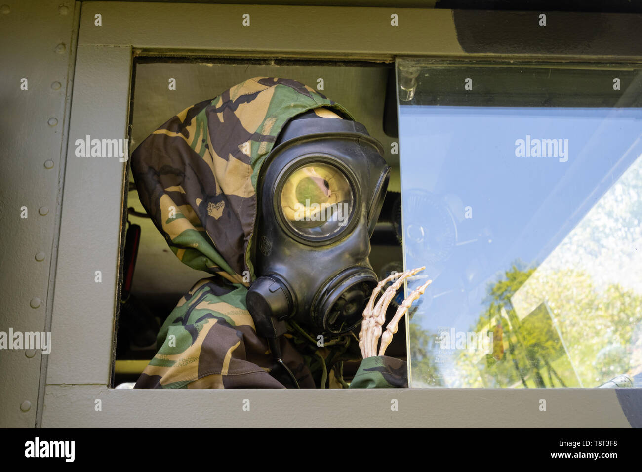 Squelette habillé comme un soldat portant un masque à gaz dans un véhicule militaire à une exposition de voiture, UK Banque D'Images