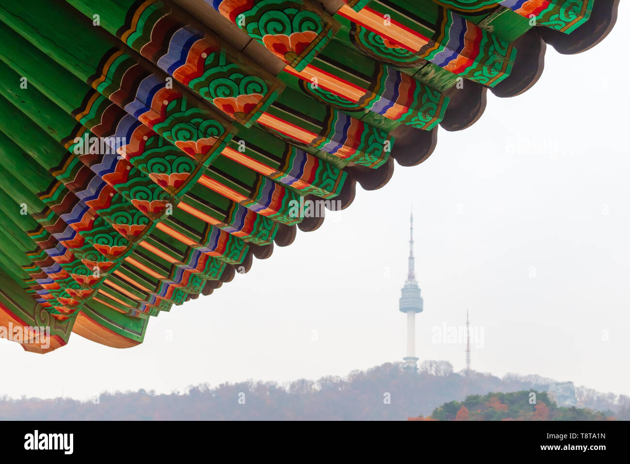 Détail de toit traditionnel coréen (ornement coloré décoré pour l'ancien palais de Corée) avec la Tour N de Séoul à l'arrière-plan Banque D'Images