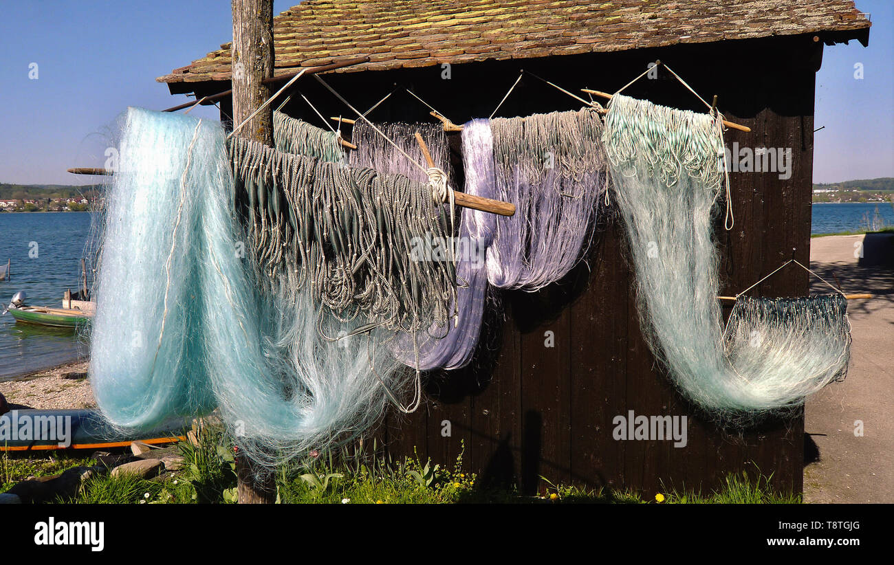 Les filets de pêche aux casiers à sec dans des tons bleu-vert en face d'une vieille maison de bois sur les rives de l'île pêche et de légumes 'la Reichenau Banque D'Images
