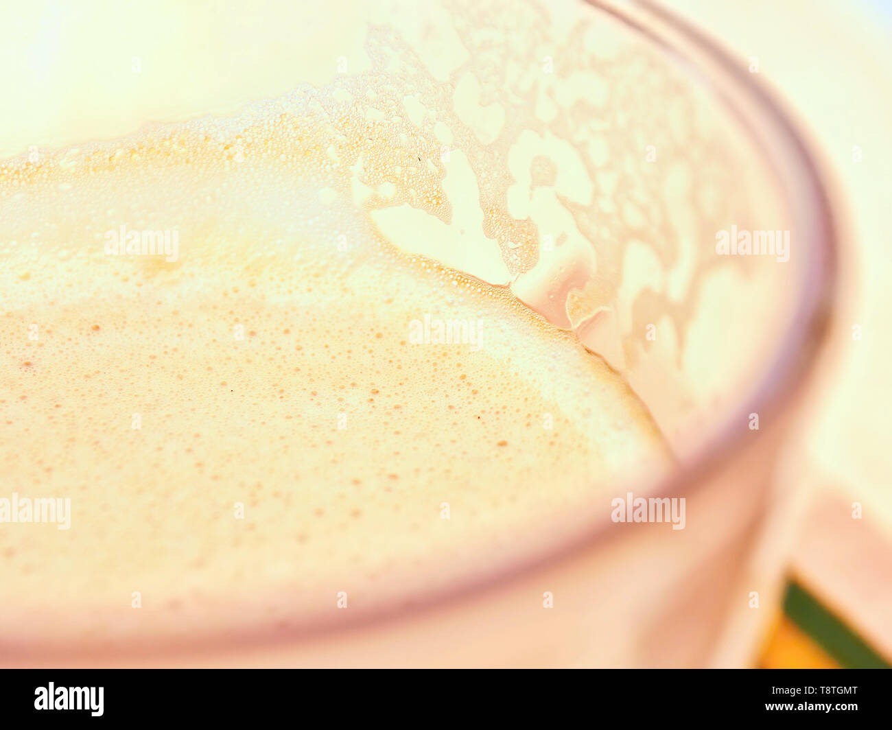 Mousse de lait d'un café au lait dans un verre en close-up, très lumineux, très doux, l'arrière-plan également, la texture. Banque D'Images