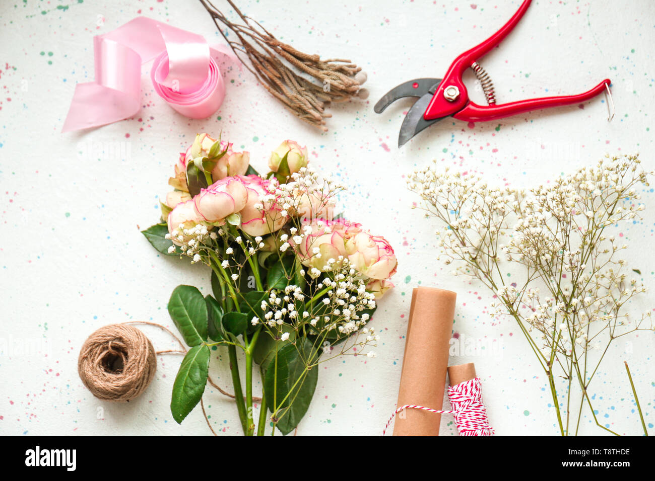 De belles fleurs avec fournitures de fleuriste sur table lumineuse Banque D'Images