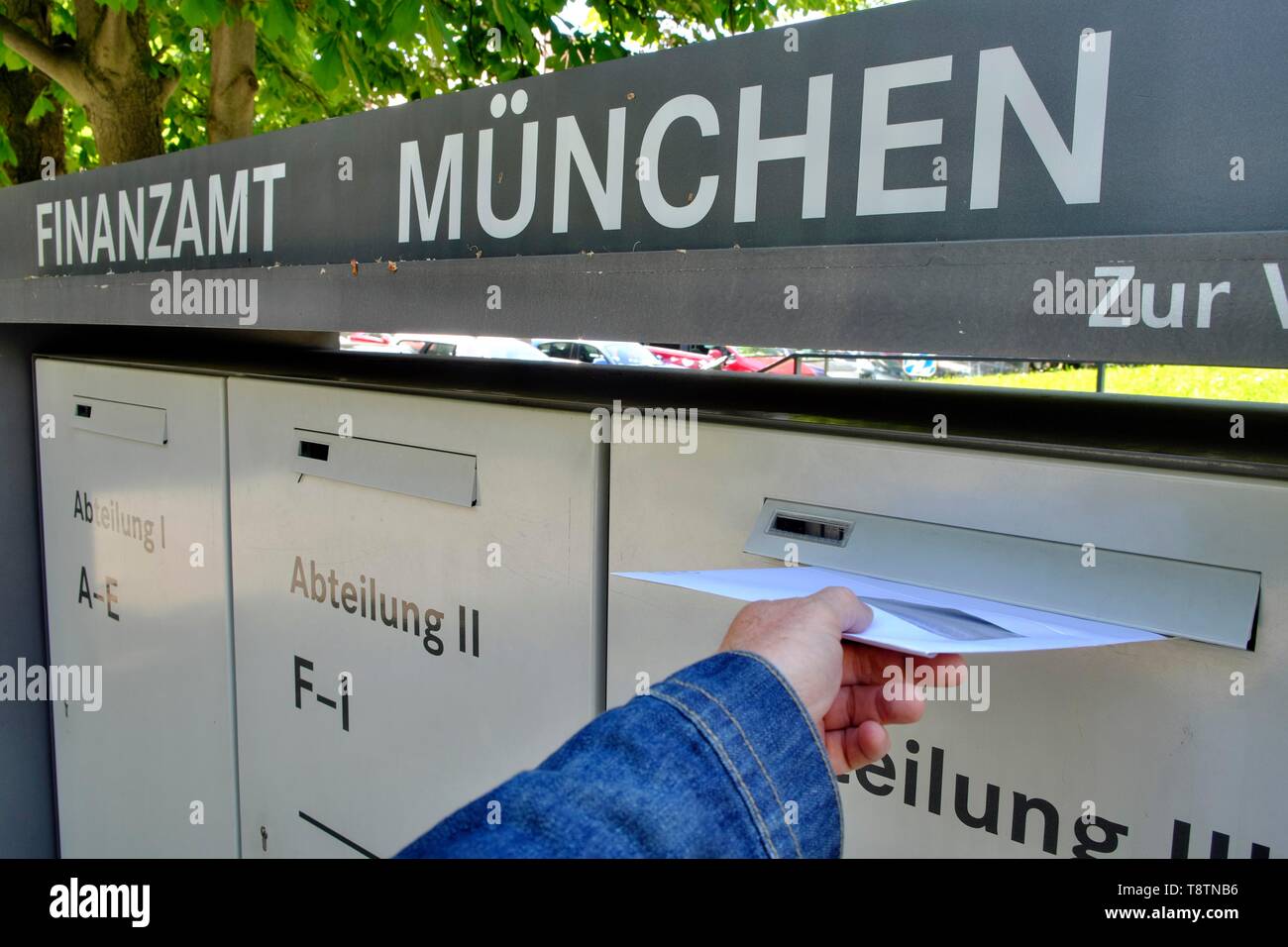 Photo symbole, jetant la main avec lettre de déclaration fiscale dans la boîte aux lettres de l Photo symbole, jetant la main avec lettre de déclaration fiscale dans la boîte aux lettres de l