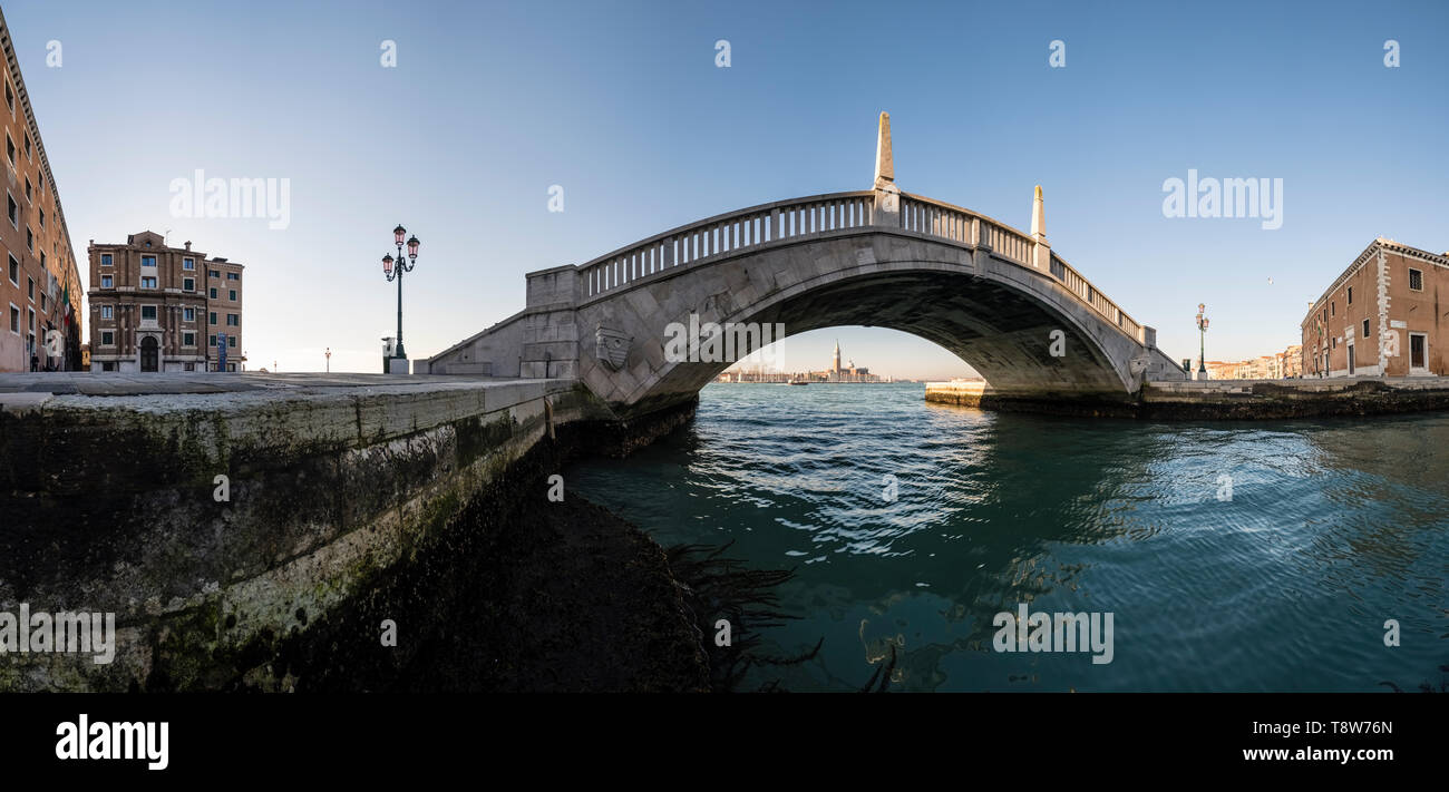 Pont de pierre traversant l'un des nombreux canaux de la ville, le Grand Canal et di San Giorgio Maggiore dans la distance Banque D'Images