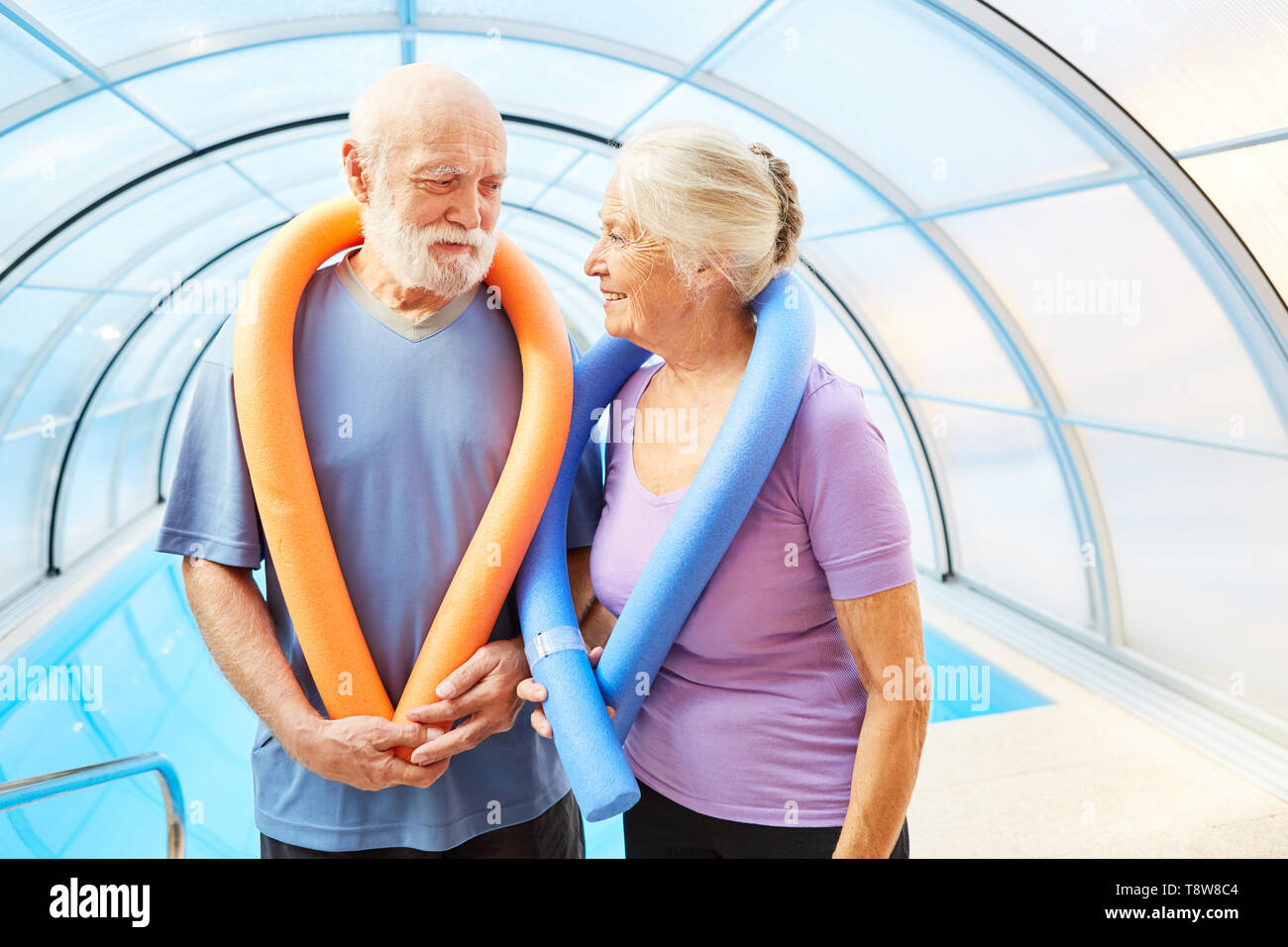 Couple de personnes âgées avec piscine et nouilles à santé sport et de l'aquafitness Banque D'Images