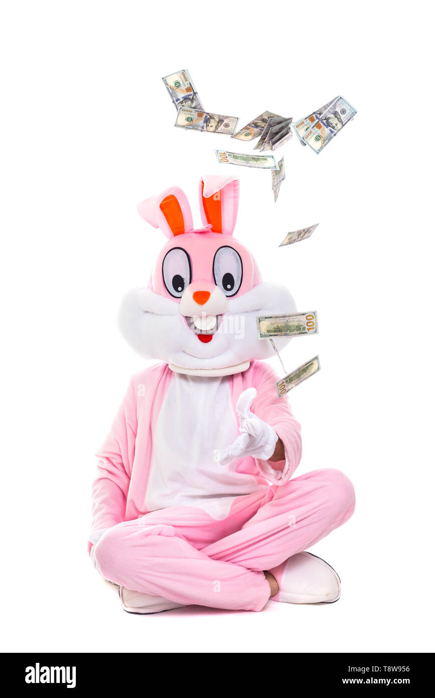 Lapin de Pâques lance de dollars, célèbre Pâques. Lucky Man riche personne sous la pluie de centaines de dollar bills Banque D'Images