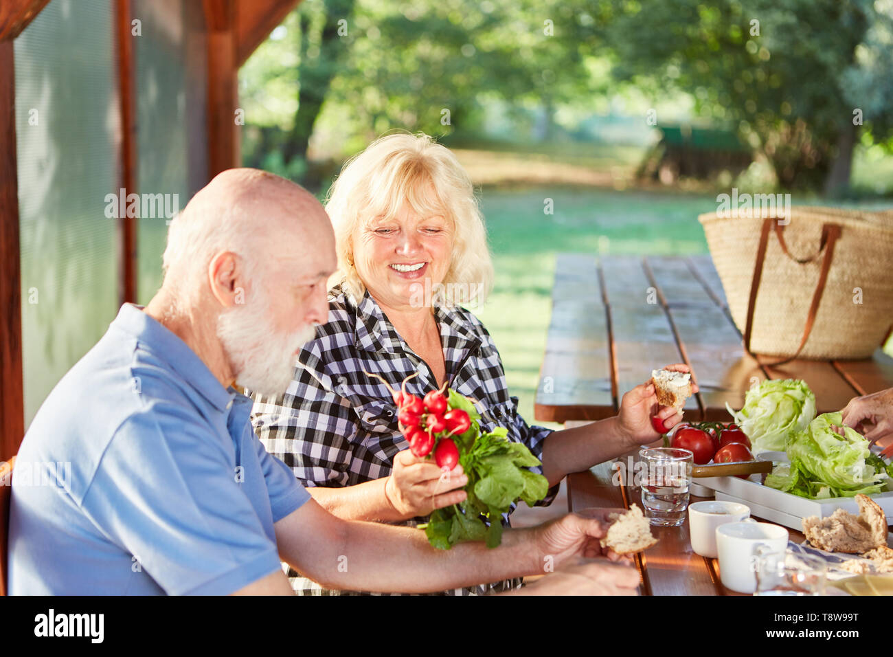 Senior couple having petit-déjeuner sain avec beaucoup de légumes frais en été Banque D'Images