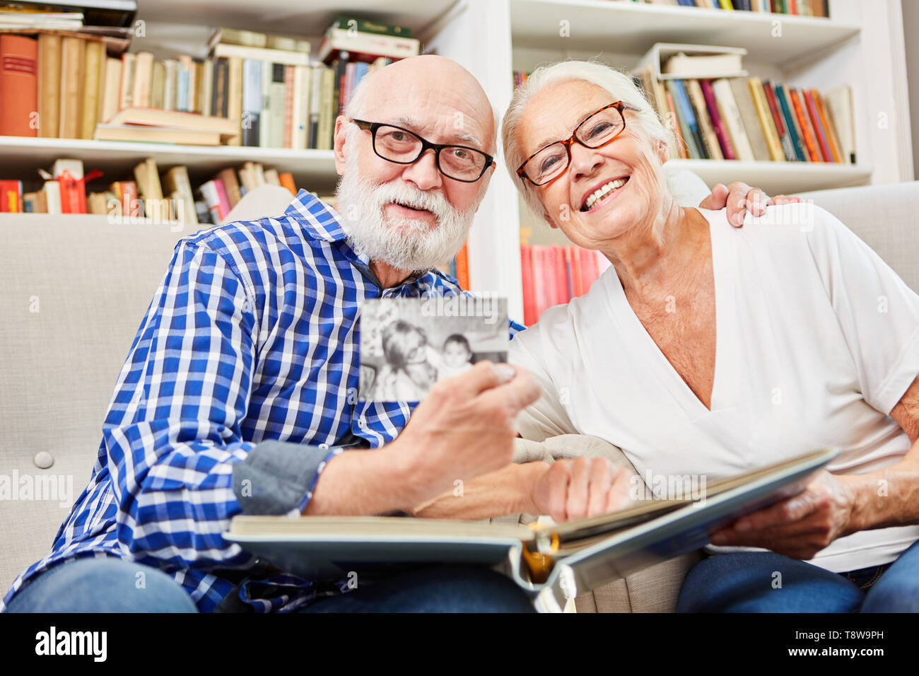 Heureux en couple est à la recherche de photos dans l'album photo dans leur appartement Banque D'Images
