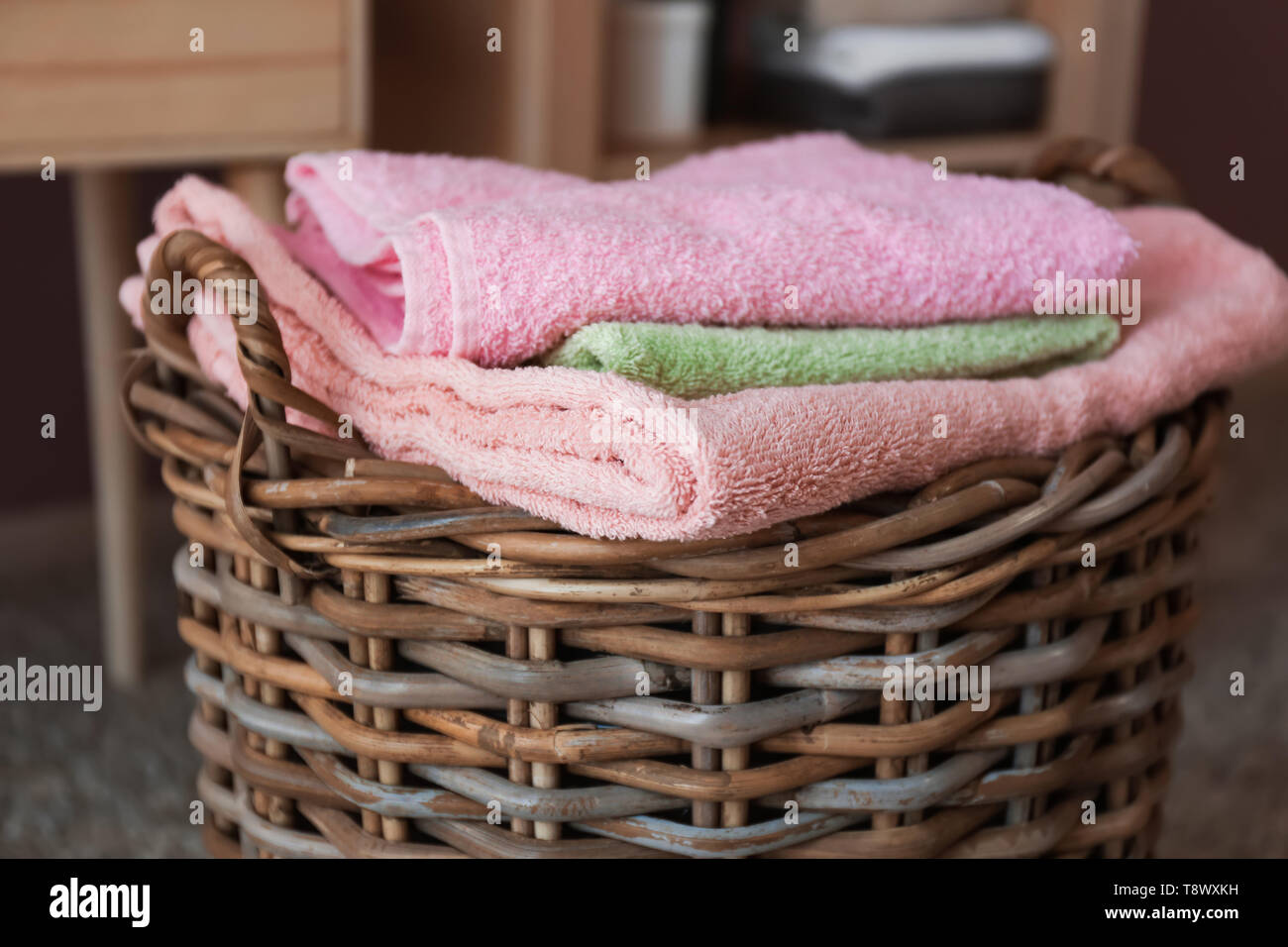 Panier en osier avec des serviettes pliées sur marbre Banque D'Images