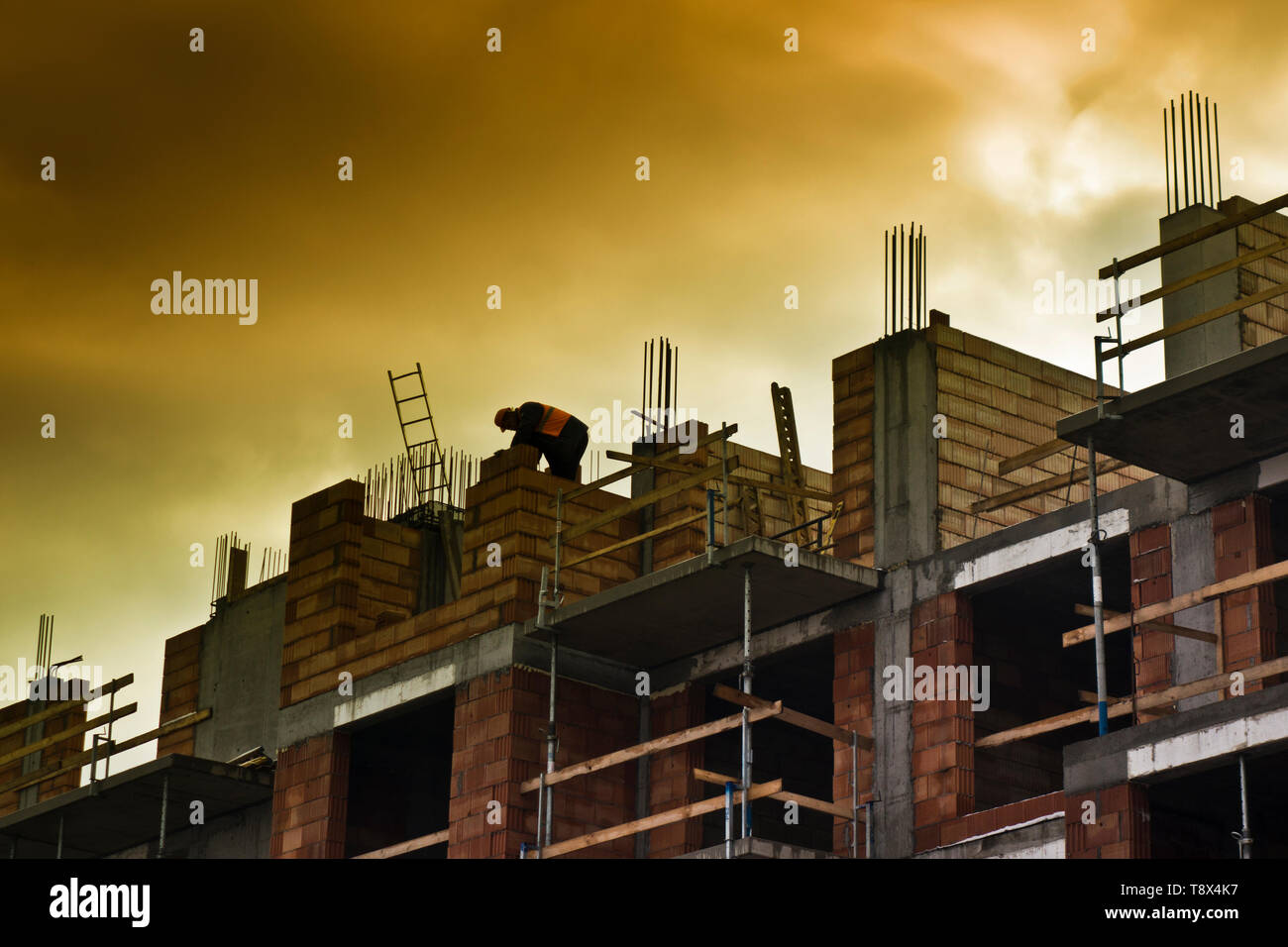 Silhouette d'un travailleur de la construction haut de page un nouveau bâtiment résidentiel à plusieurs étages en construction Banque D'Images