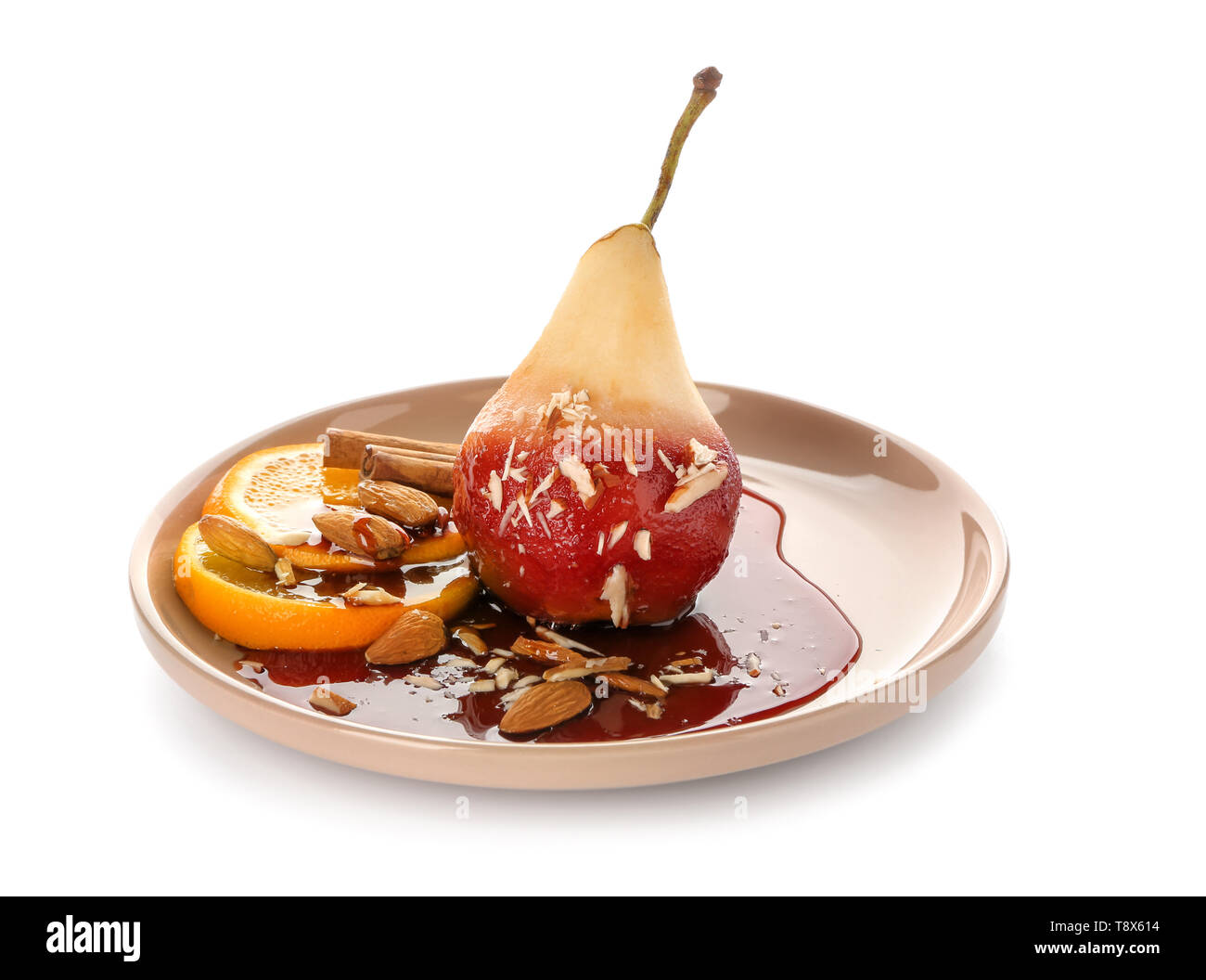 Plaque avec de délicieux poire pochée au vin rouge sur fond blanc Banque D'Images