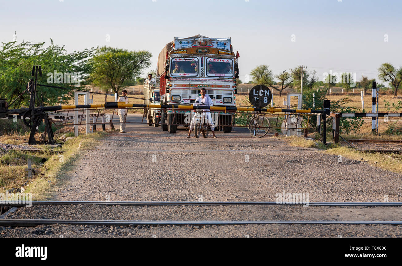 En attendant de traverser la voie de chemin de fer au passage à niveau, dans le Rajasthan, Inde Banque D'Images