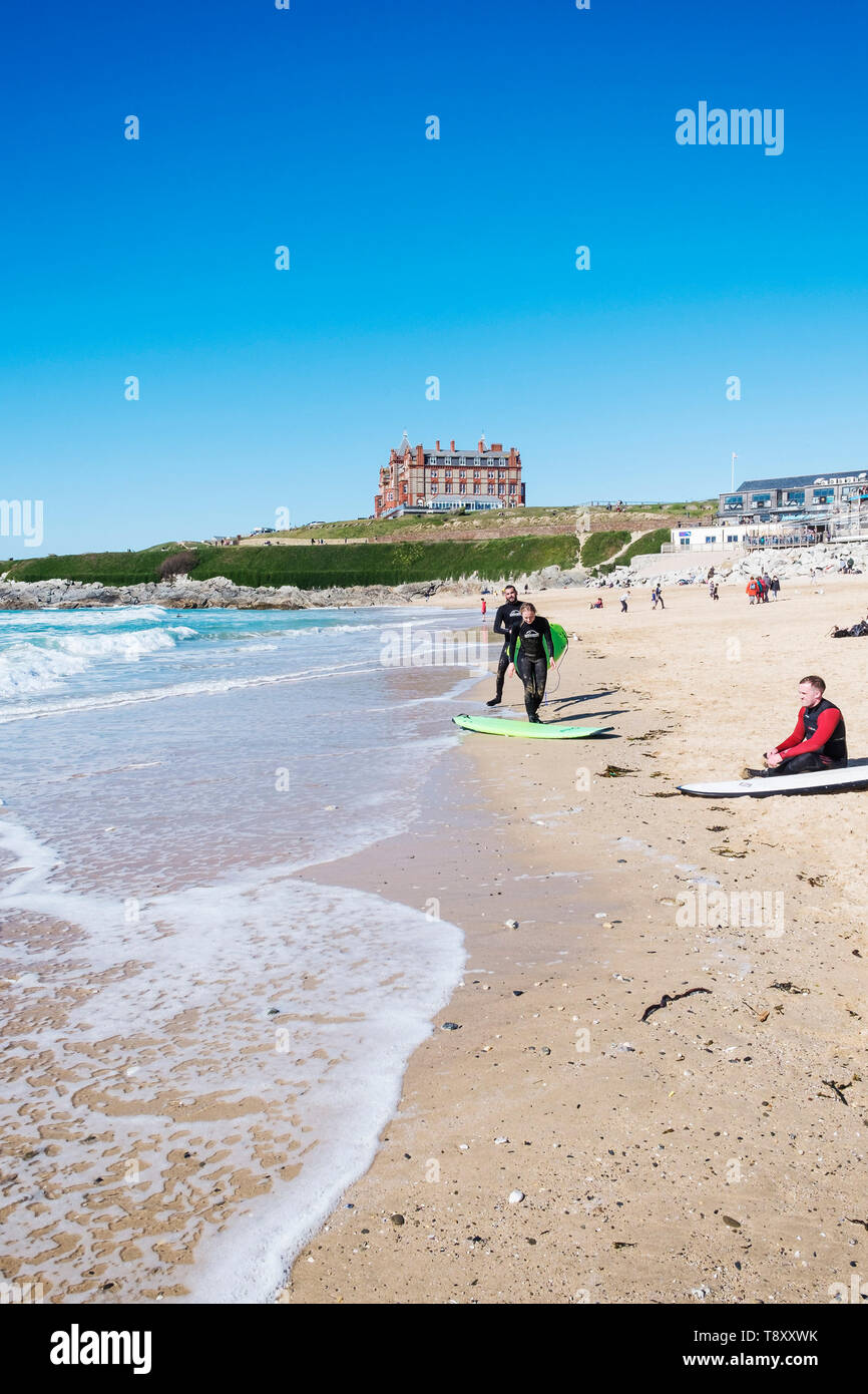 Balades les surfeurs sur la plage de Fistral hotspot surf à Newquay en Cornouailles. Banque D'Images