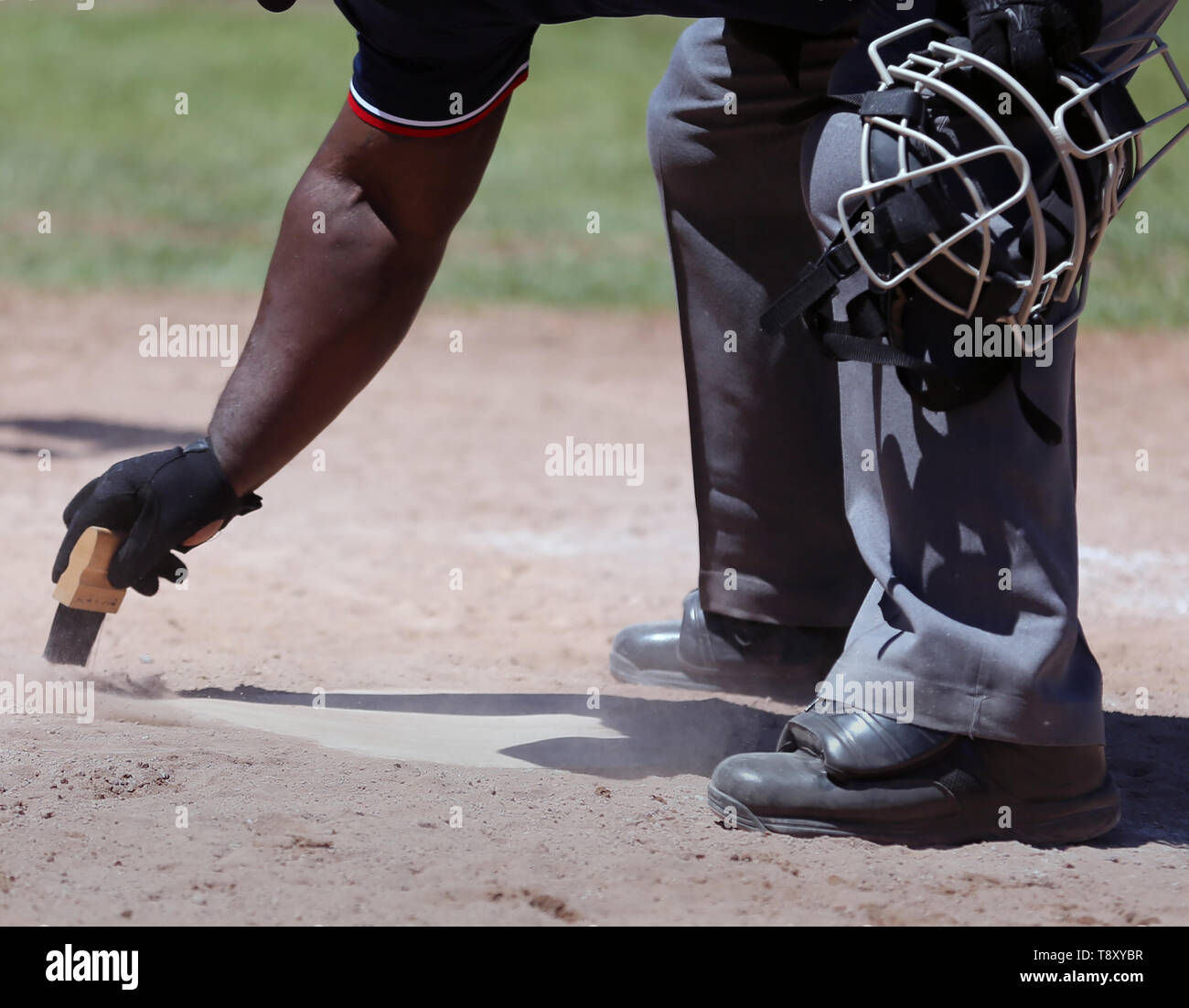 African American juge-arbitre plaque accueil nettoyage dans une école secondaire d'un match de baseball Banque D'Images