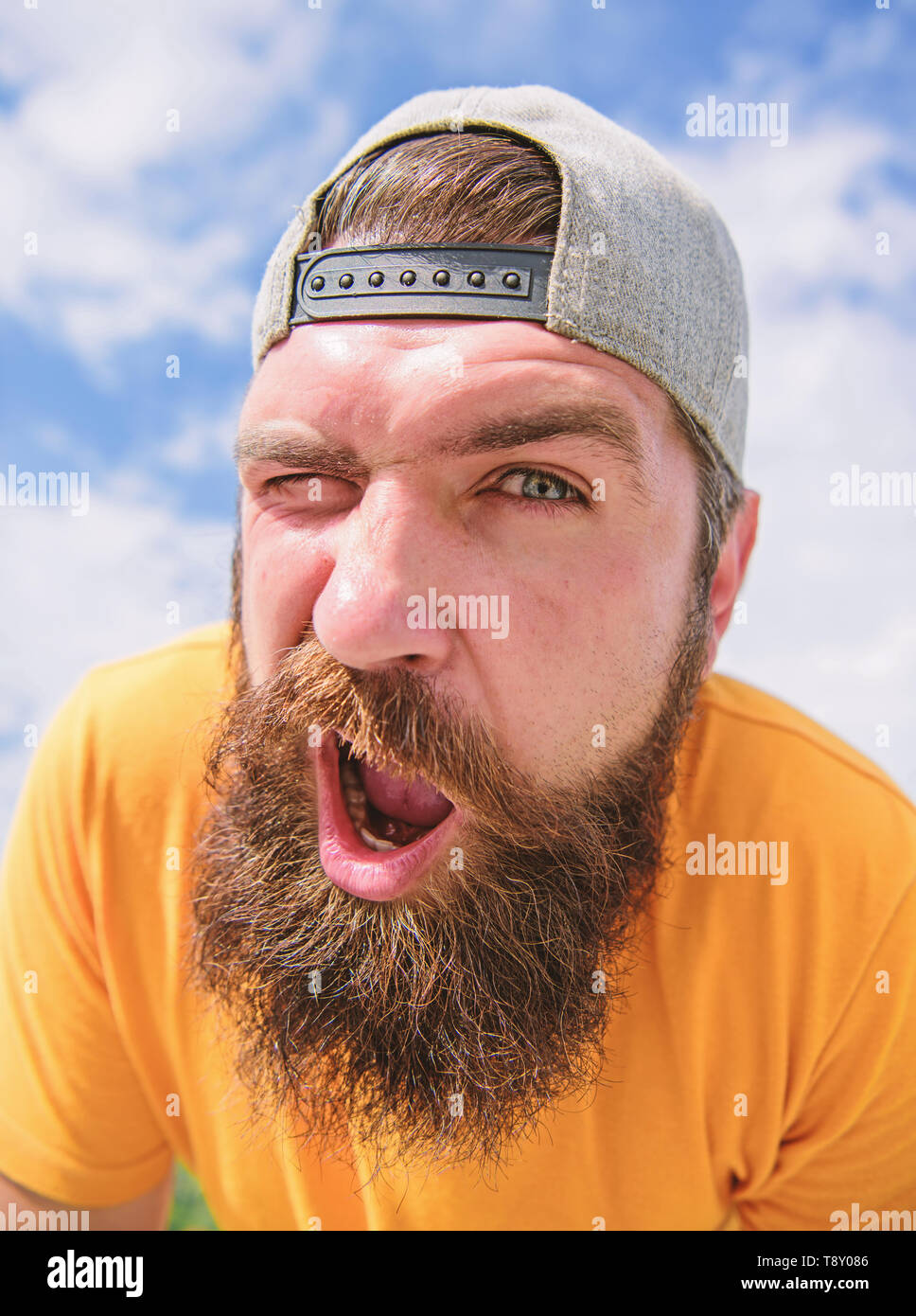 Homme avec barbe journée ensoleillée. Soins de la peau et du bronzage.  Hipster barbu avec moustache élégante. Jeune et insouciante. Hipster barbu  porter le chapeau. Concept de printemps. Hipster avec rousseur face