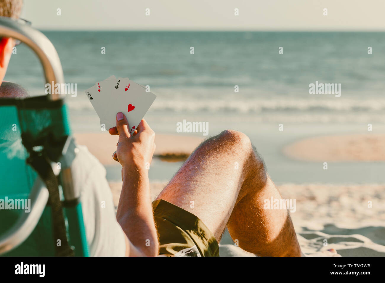 Jeu de carte Plein air à plage, quatre as dans la main du joueur avec fond de ciel et mer Banque D'Images