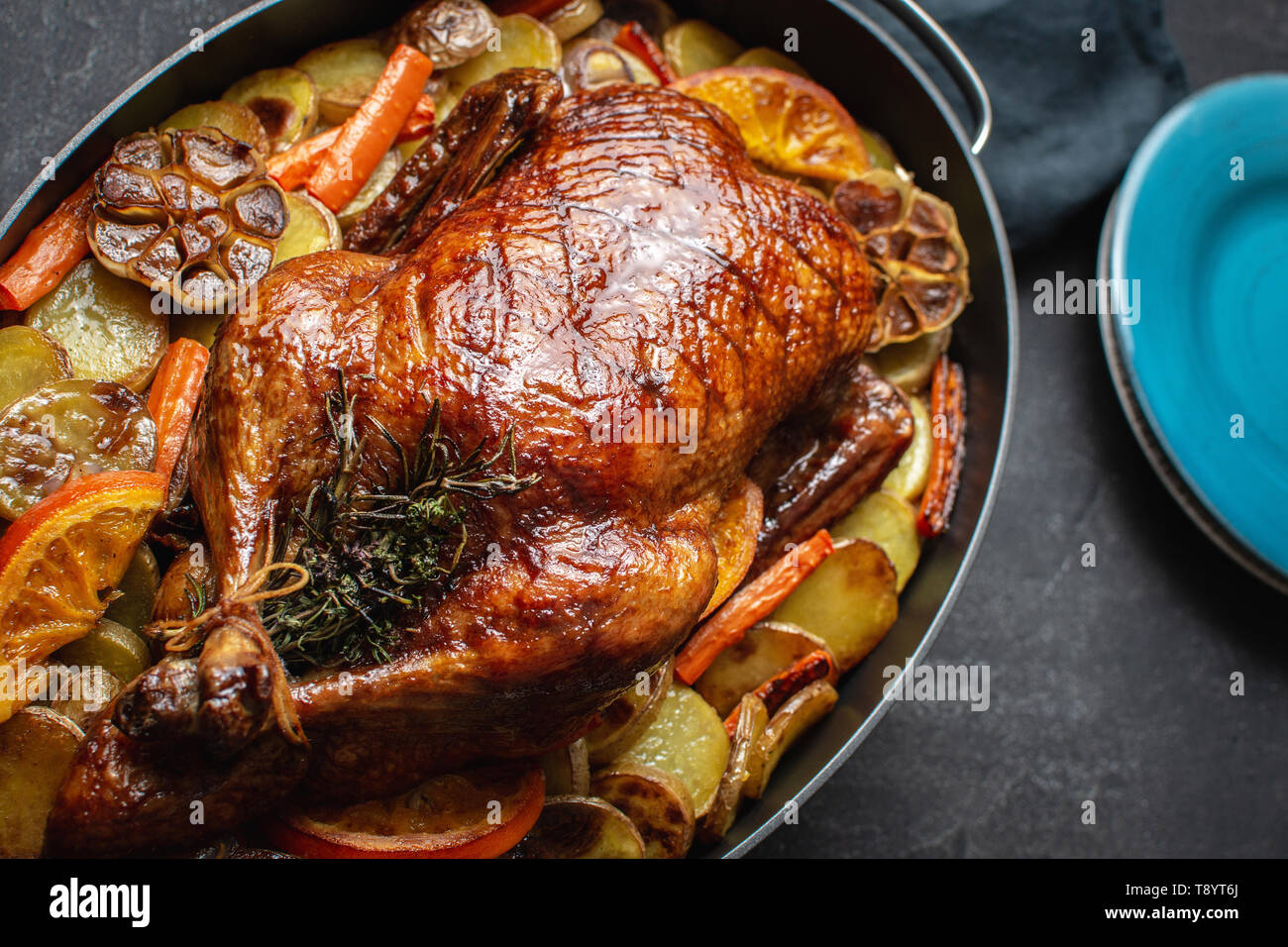 De canard entier cuit au four avec des pommes de terre, carottes, oranges,  romarin et thym Photo Stock - Alamy