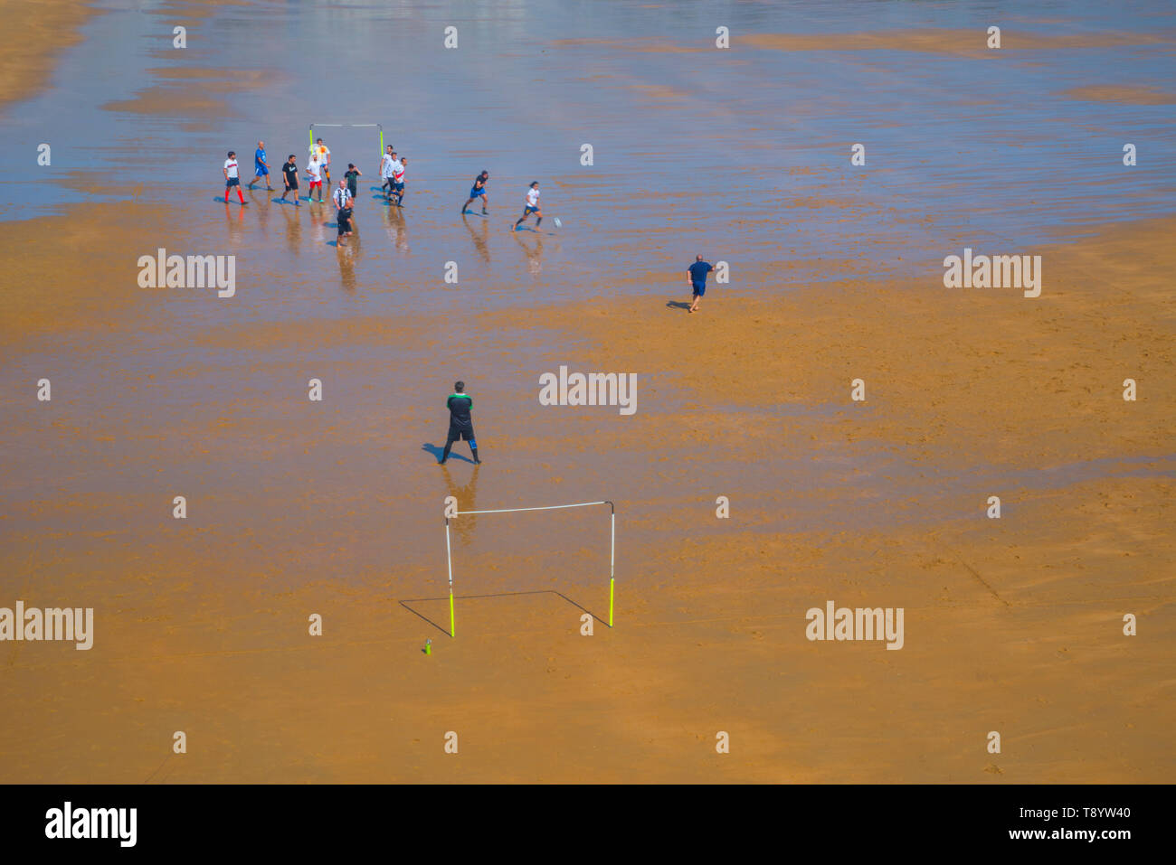 Les hommes jouent au football à la plage. El Sardinero, Santander, Espagne. Banque D'Images