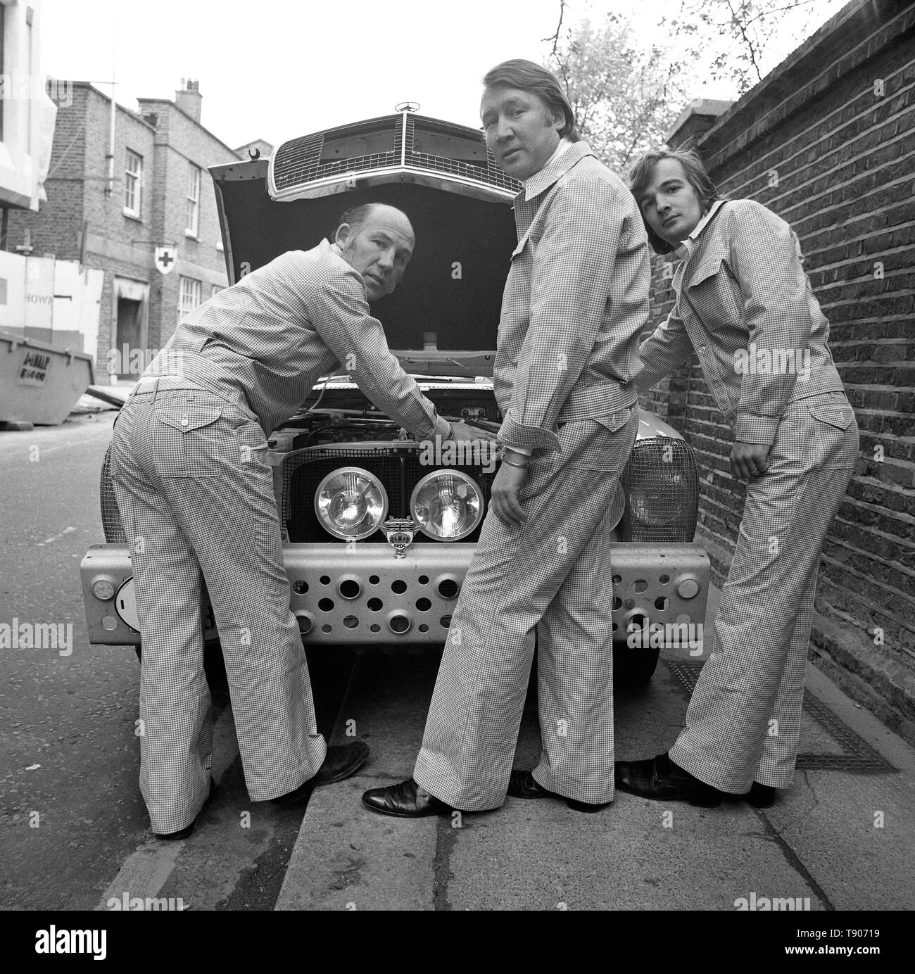 Contrôler sur leur voiture de rallye de la Coupe du monde - une Mercedes 280E - à Londres sont propriétaire-conducteur Michael Taylor (au centre), co-pilote Stirling Moss (l) et Alan mécanicien vendre. L'équipe est aussi la recherche sur leurs nouveaux costumes (rallye coton vérifier par Simpsons de Piccadilly). Les 11 000 milles commence dimanche prochain rallye de Wembley et se termine à Munich le 25 mai. Banque D'Images