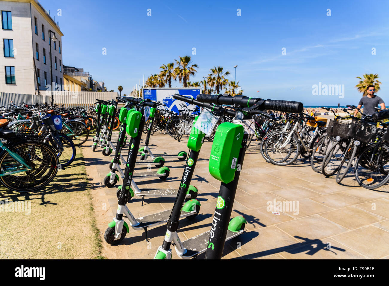 Valencia, Espagne - 12 mai 2019 : Des Vélos à louer pour les touristes et des scooters électriques de la chaux, garé sur la plage de Valence. Banque D'Images