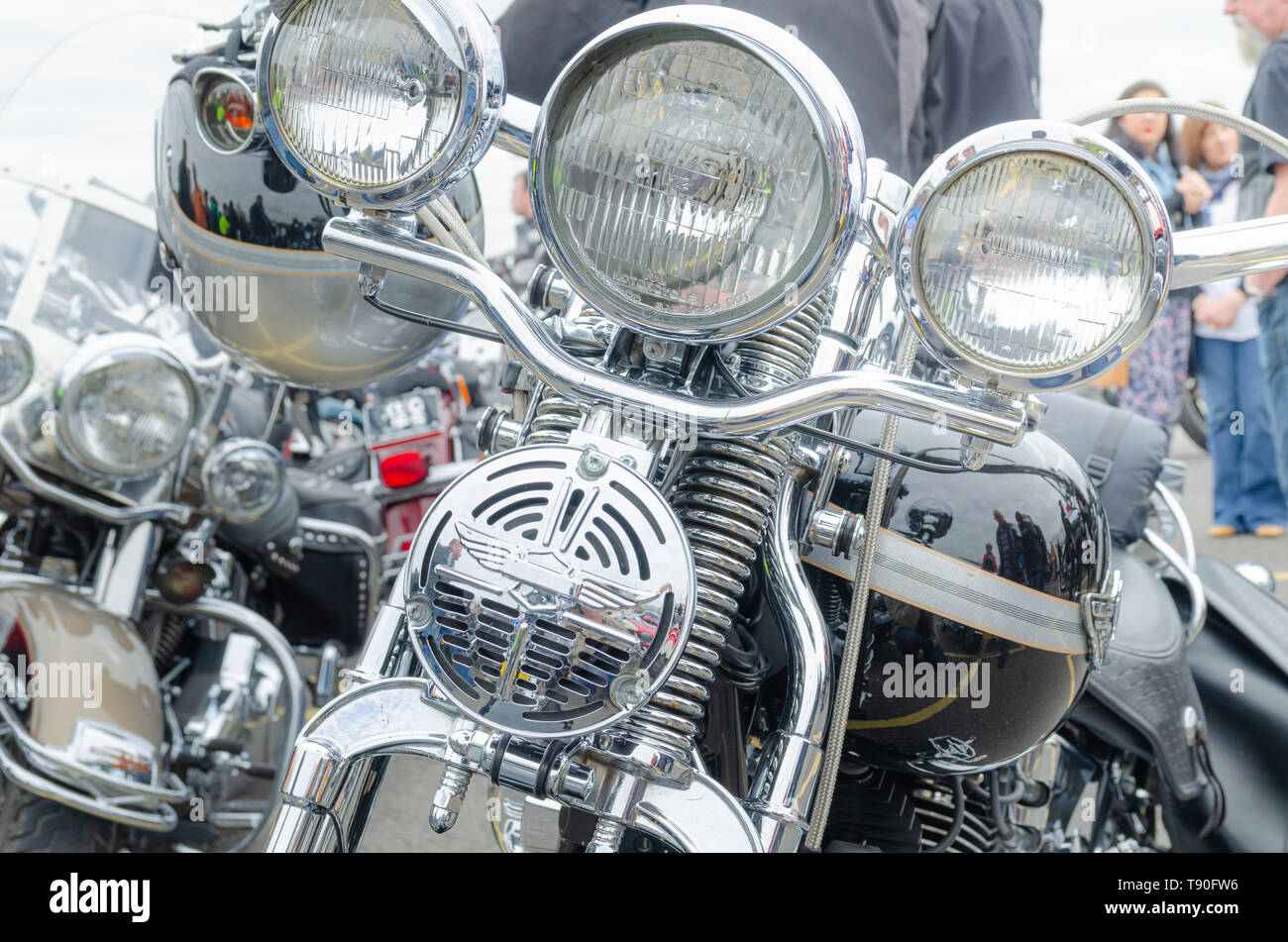 Rédaction d'illustration : un ensemble de barres de poignée chrome poli, de la lumière et de ressorts de suspension enroulée sur une moto Harley Davidson garée. Banque D'Images