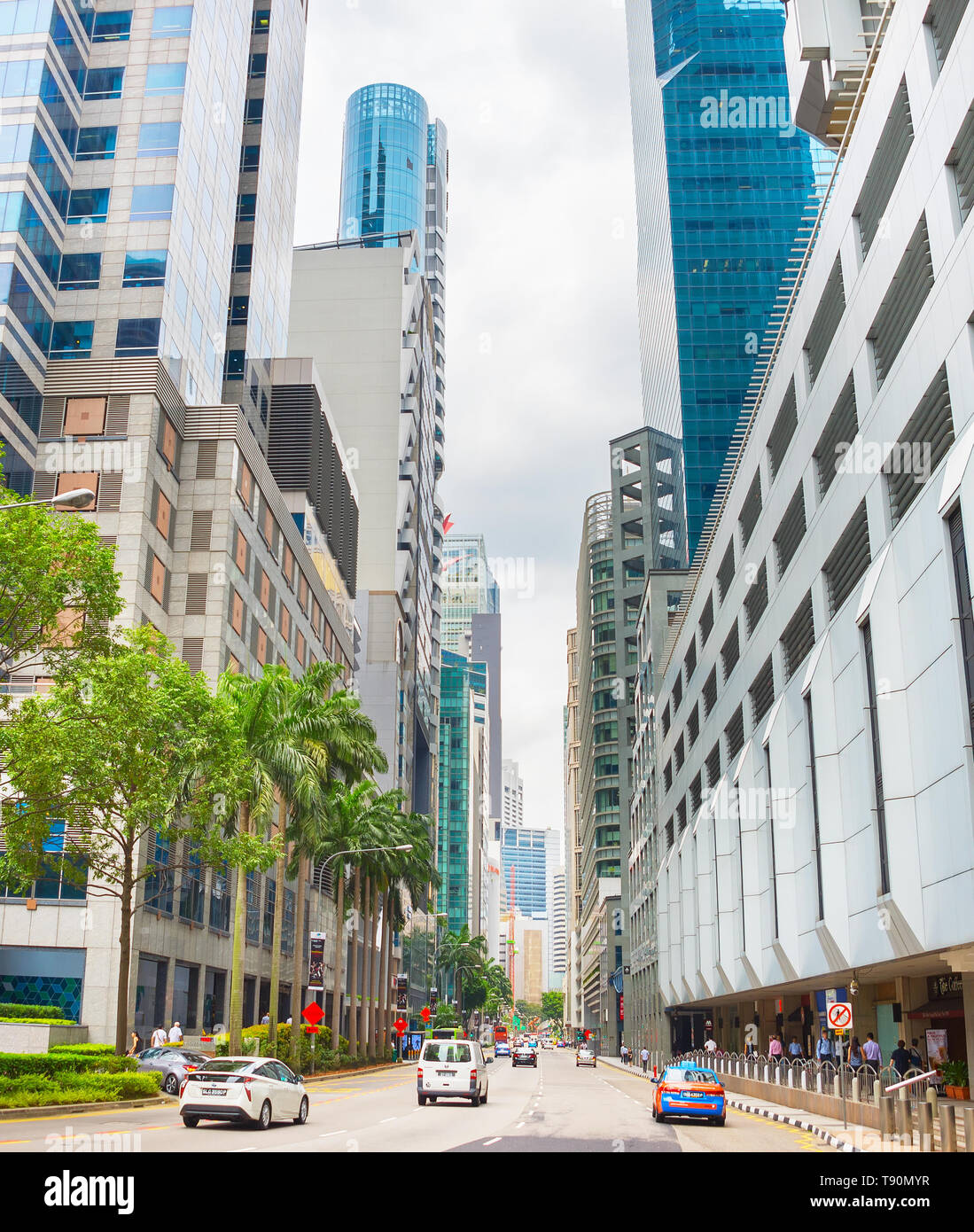 Singapour - Le 16 janvier 2017 : Vue de dessous de la rue du centre-ville de Singapour à la circulation sur route, à l'architecture moderne, les gens à pied et arbres verts Banque D'Images