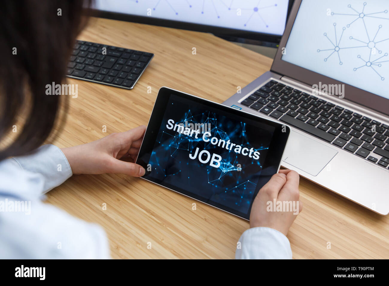Femme d'affaires à l'aide de contrats Smart Job. Illustration de l'Ethereum Blockchain sur l'écran du Tablet PC, et l'ordinateur portable. Banque D'Images